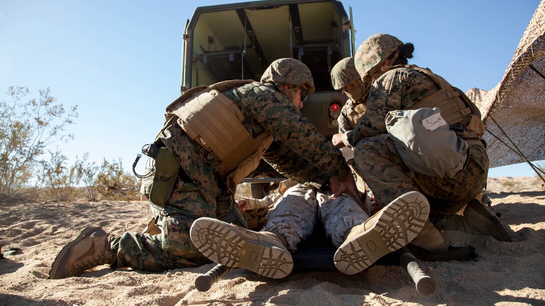 Hospital corpsmen and Marines check a simulated casualty and remove their body armor during Exercise Steel Night’s mass casualty drill at Marine Corps Air Ground Combat Center Twentynine Palms, Calif., Dec. 12, 2015. The drill tested the 1st Marine Division’s ability to react to a large influx of injuries and wounds from battling the enemy. Steel Knight provides tough, realistic training for the Marines and sailors of 1st Marine Division.