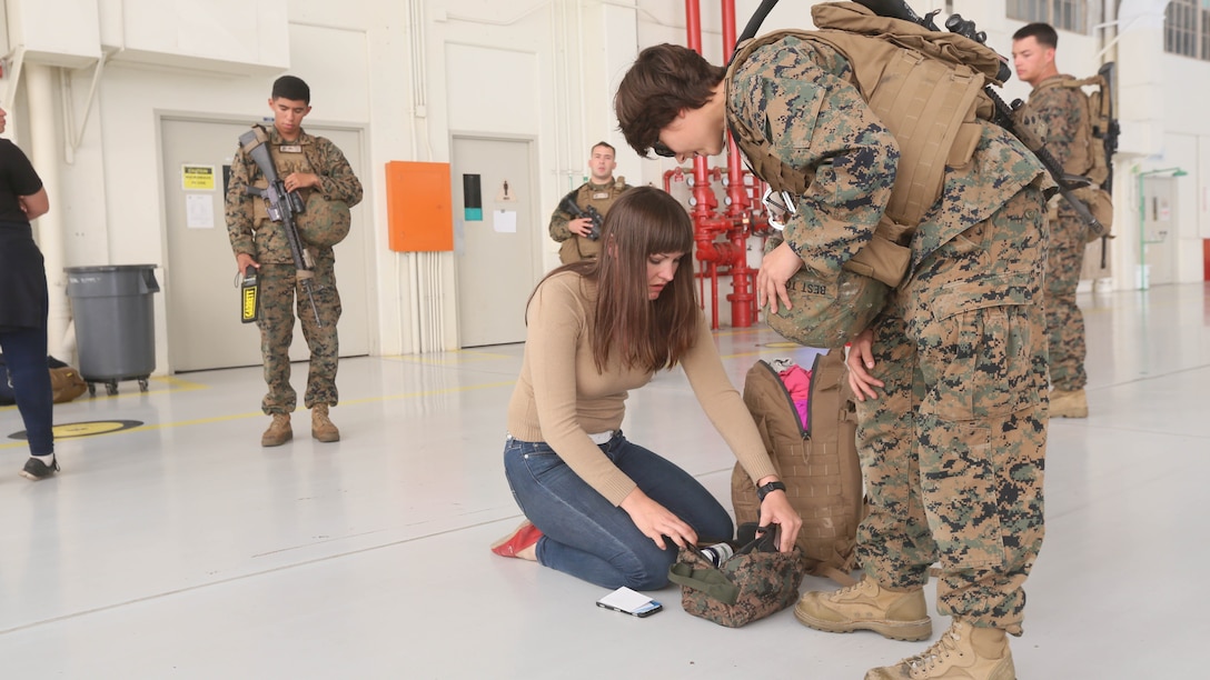 Cpl. Tori Best, a U.S. Marine with the 13th Marine Expeditionary Unit, directs an evacuee to empty the contents of his backpack while checking for contraband during a simulated noncombatant evacuation as part of Certification Exercise, Dec. 9, 2015. Noncombatant evacuations are one of the MEU's mission essential tasks, which it is specially trained to complete anywhere in the world within hours of notification. 
