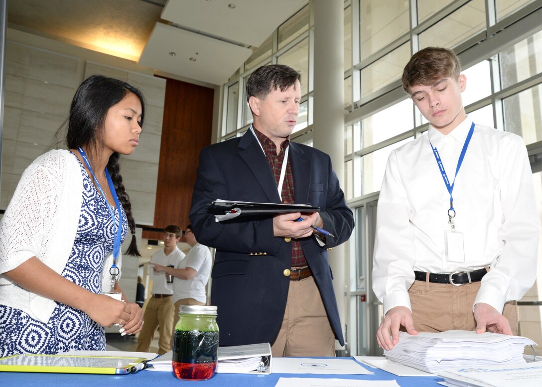 Russ Dunford, U.S. Army Engineering and Support Center, Huntsville chief of operations, speaks to McCoy Floyd, left, and Zachery Amerson, Palmetto Scholars Academy, North Charleston, South Carolina, about their conceptual payload during the InSPIRESS event at UA Huntsville, Dec. 11. 