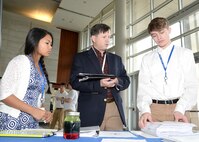 Russ Dunford, U.S. Army Engineering and Support Center, Huntsville chief of operations, speaks to McCoy Floyd, left, and Zachery Amerson, Palmetto Scholars Academy, North Charleston, South Carolina, about their conceptual payload during the InSPIRESS event at UA Huntsville, Dec. 11. 