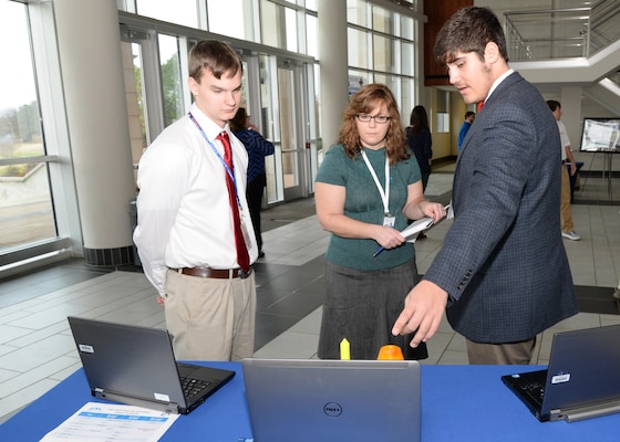 Betina Johsnon, U.S. Army Engineering and Support Center, Huntsville Ordnance and Explosives Design Center chief, speaks to Sebastian Stewart, left, and Liam Bair, Hartselle High School, Hartselle, Alabama, about their conceptual payload during the InSPIRESS event at UA Huntsville, Dec. 11. 