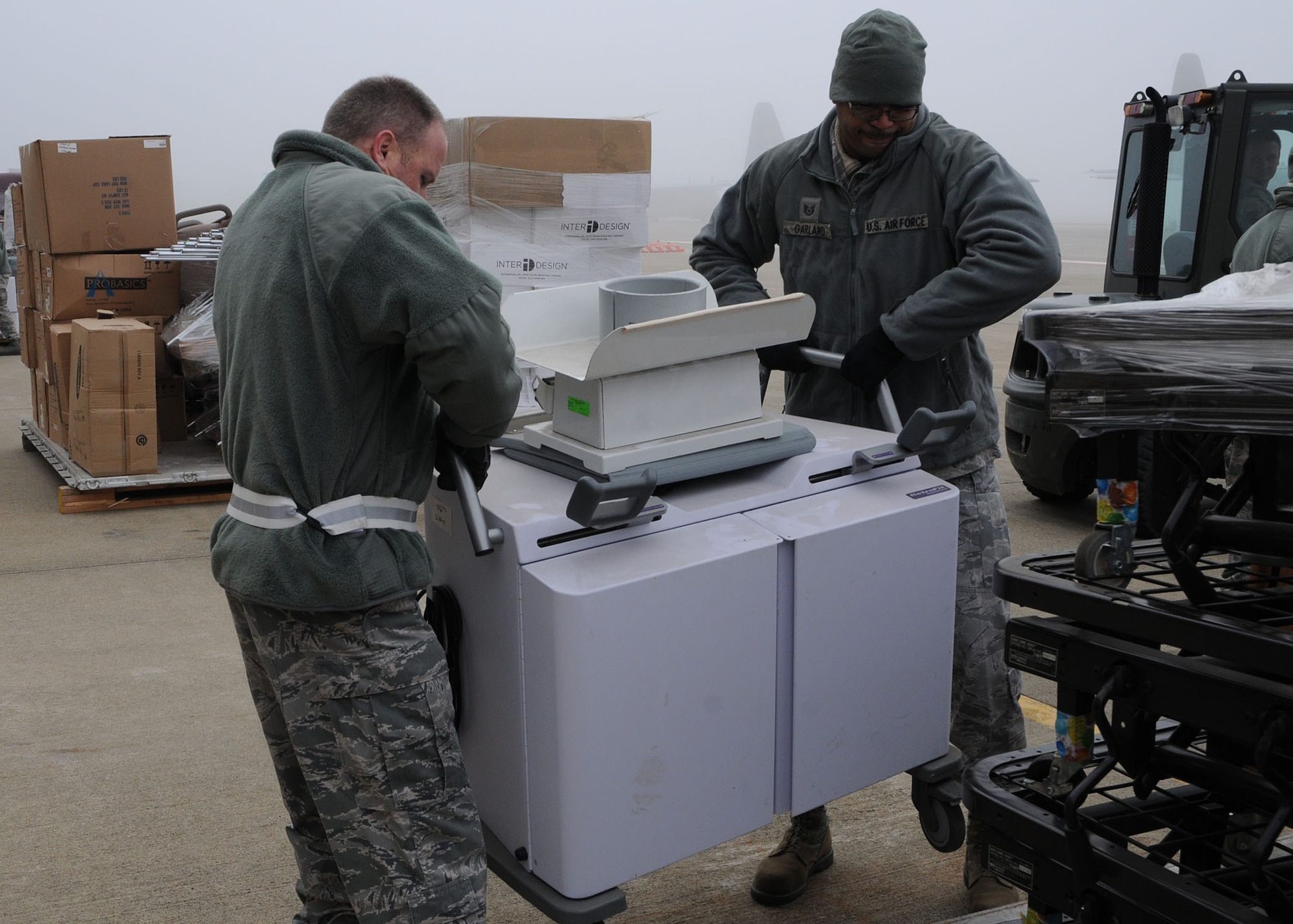 Tech. Sgt.  Jonathan Garland and Senior Airman Andrew Albrecht, air transportation specialists assigned to the 76th Aerial Port Squadron, lift cargo onto a pallet during preparation for a Denton Mission here, Dec. 5 2015. The Denton program allows the Air Force to provide transportation of privately donated humanitarian assistance cargo to foreign countries using military transportation on a space-available basis. The cargo Garland and Albrecht are palletizing is bound for Honduras. (U.S. Air Force photo/Tech. Sgt. Rick Lisum)