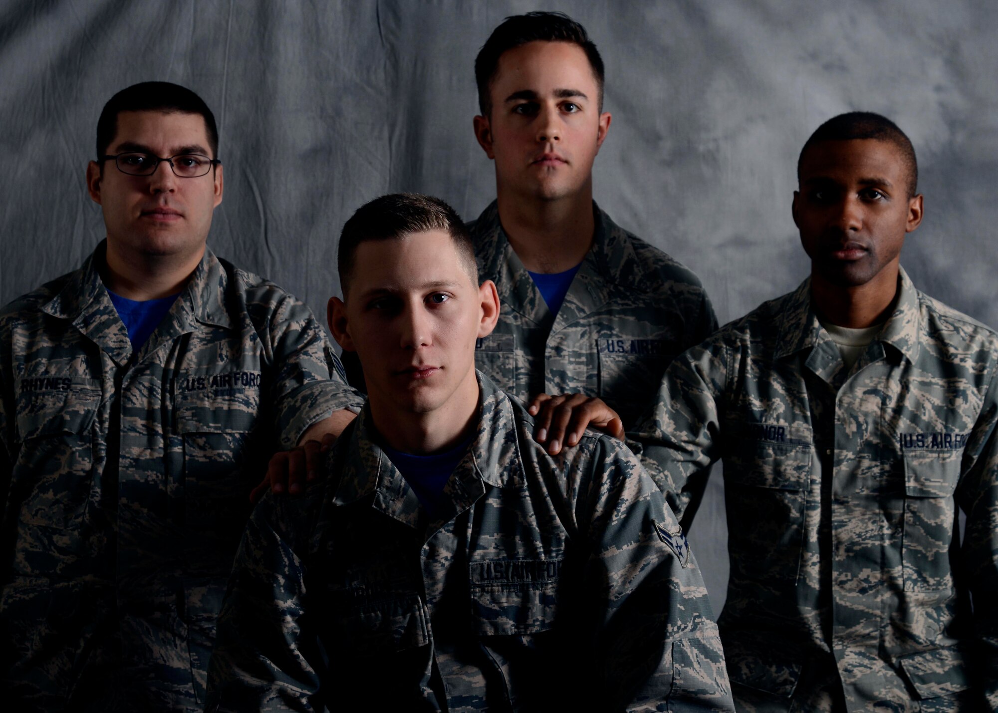 Three 22nd Air Refueling Wing Public Affairs Airmen reach out to Airman 1st Class Christopher Thornbury, front-center, Dec. 11, 2015, at McConnell Air Force Base, Kan. Thornbury says his Air Force family has been with him for over a year and helped him through the loss of his son, Emmitt Alan Thornbury. (U.S. Air Force photo/Senior Airman Colby Hardin)