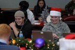 Volunteer tracker Matthew Harvey joined his mother Col. Tina Harvey to help answer emails from children and parents across the globe while at the NORAD Tracks Santa Operations Center on Peterson Air Force Base, Colorado., Dec. 24, 2014. 