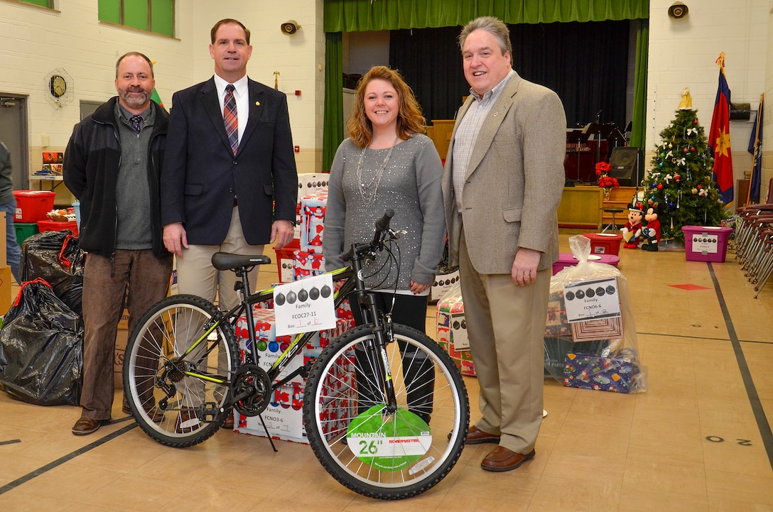 Don Phillips (left), DLA Installation Support at Battle Creek’s acting site director, and DLA Disposition Services Director Mike Cannon (left center) and Logistics Information Services Director Ray Zingaretti join Tiffany Schmidt, a DLA marketing specialist and the DLA coordinator for the Adopt a Family campaign, as agency employees help the Salvation Army distribute the food and items collected.