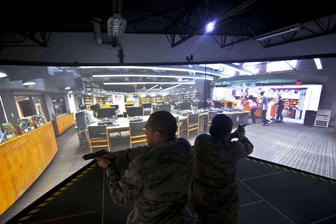 Air Force Senior Airmen Steven Frank, left, and Samantha Welsh respond to a simulated threat in a firearms training simulator at a U.S. Marshal site in Lawrenceville, N.J., Dec. 12, 2015. Frank and Welsh are assigned to the New Jersey Air National Guard's 108th Wing. U.S. Air National Guard photo by Tech. Sgt. Matt Hecht