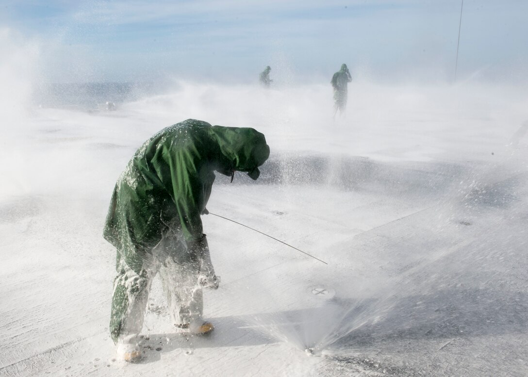 Sailors assigned to the repair division of the amphibious assault ship USS Makin Island conduct a washdown in the Pacific Ocean, Dec. 9, 2015. The Makin Island is finishing maintenance in San Diego. U.S. Navy photo by Petty Officer 3rd Class Dennis Grube
