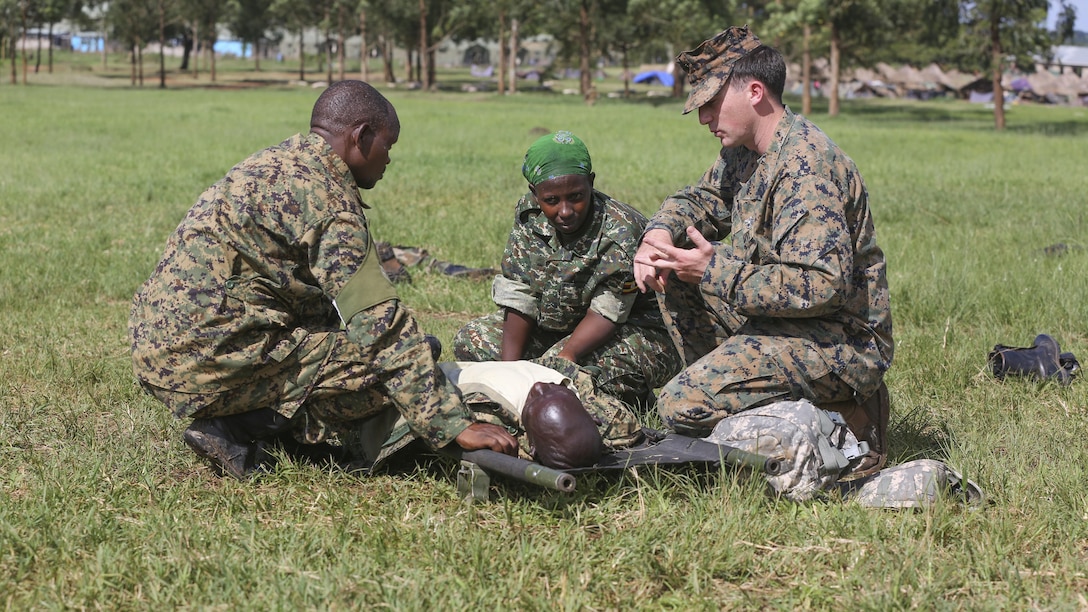 Petty Officer 2nd Class Robert Otte (left), corpsman and chief instructor with Special-Purpose Marine Air-Ground Task Force Crisis Response-Africa, instructs a Uganda People’s Defense Force medic during a tactical combat casualty care exercise at Camp Singo, Uganda, Nov. 30, 2015. The UPDF medics and corpsmen are training together to improve tactical medical care skills while strengthening the bond between the partner nations. 