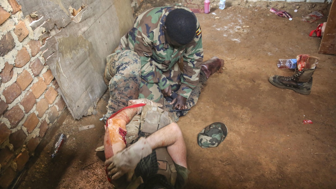 Petty Officer 2nd Class Robert Otte, corpsman and chief instructor with Special-Purpose Marine Air-Ground Task Force Crisis Response-Africa, acts as a casualty as a Uganda People’s Defense Force medic applies a tourniquet during a notional tactical combat casualty care exercise at Camp Singo, Uganda, Dec. 10, 2015. The UPDF medics and corpsmen are training together to improve tactical medical care skills while strengthening the bond between the partner nations. 