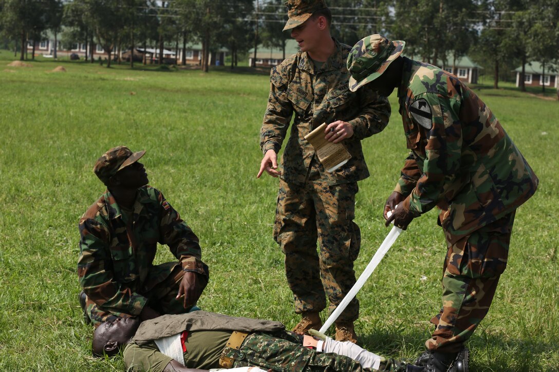 Petty Officer 3rd Class Paxton Dowd (middle), corpsman with Special-Purpose Marine Air-Ground Task Force Crisis Response-Africa, evaluates Uganda People’s Defense Force medics during a tactical combat casualty care exercise at Camp Singo, Uganda, Dec. 8, 2015. The UPDF medics and corpsmen are training together to improve tactical medical care skills while strengthening the bond between the partner nations. 