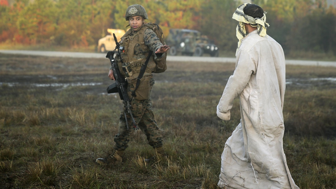 A team leader with 2nd Air Naval Gunfire Liaison Company, II Marine Headquarters Group, motions to a role player at Marine Corps Base Camp Lejeune, N.C., during a Security Assistance Liaison Team training exercise to improve their ability to work with coalition forces, Dec. 10, 2015. The Security Assistance Liaison Team will support Operation Resolute Support in Afghanistan under the authority of United Nations Security Council Resolution 2189.  