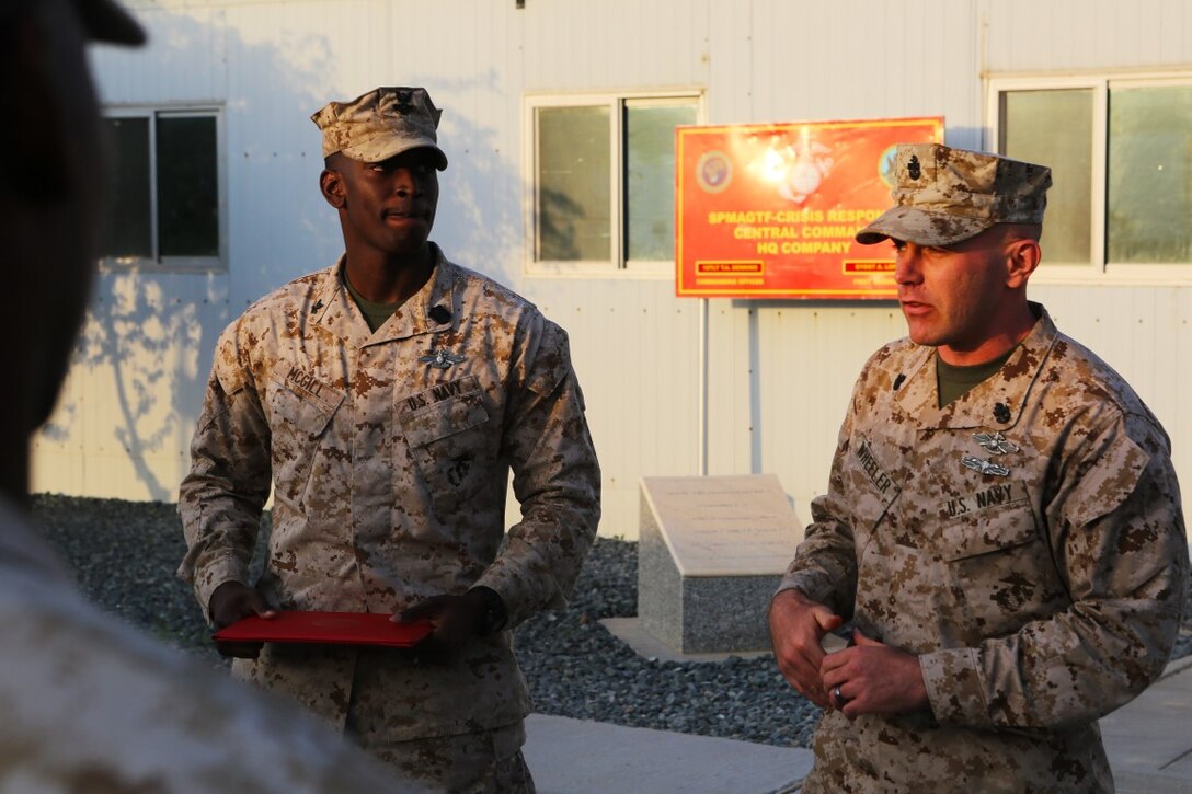 U.S. Navy Chief Petty Officer Casey Wheeler, right, the senior enlisted Navy leader with Special Purpose Marine Ground Task Force—Crisis Response—Central Command, speaks of the hard work and dedication that U.S. Navy Petty Officer 2nd Class Ambrose McGill, a hospital corpsman with SPMAGTF CR-CC, displayed in order to earn his Fleet Marine Force pin during a recognition ceremony at an undisclosed location in Southwest Asia, Dec. 12, 2015. The FMF pin is presented to a Sailor who has displayed the gumption to accomplish the arduous tasks required to earn the pin. (U.S. Marine Corps photo by Sgt. Owen Kimbrel/RELEASED)
