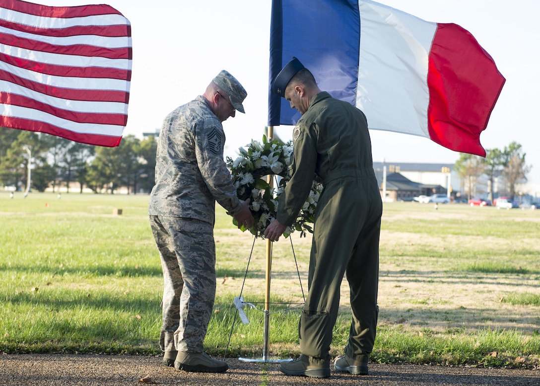 Air Force Col. Pete Fesler, 1st Fighter Wing commander, and Chief Master Sgt. Ronald Beadles, 1st Fighter Wing chief master sergeant, lay a wreath in front of a French flag at Joint Base Langley-Eustis, Va., Dec. 11, 2015. The wreath-laying ceremony was held in remembrance of the victims of recent terrorist attacks in Paris. U.S. Air Force photo by Airman 1st Class Derek Seifert