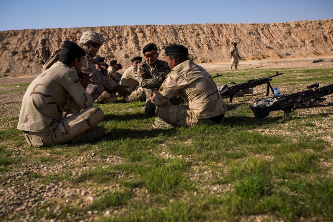 U. S. Marine Staff Sgt. Phillip Kirkham, back left, with security forces, Weapons Company, 1st Battalion, 7th Marine Regiment, Special Purpose Marine Air-Ground Task Force-Crisis Response-Central Command (SPMAGTF-CR-CC), converses with Iraqi soldiers with the 75th Brigade, 3rd battalion, 7th Iraqi Army Division, at Al Asad Air Base, Iraq, Nov. 29, 2015. Kirkham is the platoon sergeant for security forces at Al Asad. Security forces provide security for the Royal Danish and Iraqi soldiers during training evolutions supporting Combined Joint Task Force-Operation Inherent Resolve’s building partner capacity (BPC) mission. (U.S. Marine Corps photo by Lance Cpl. Clarence Leake/Released)