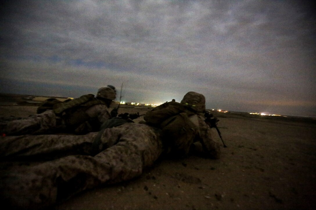 U.S. Marines Sgt. Daniel Scotto, left, a squad leader, and Lance Cpl. Josh Hagler, an infantry rifleman, both with Bravo Company, 1st Battalion, 7th Marine Regiment, Special Purpose Marine Air Ground Task Force – Crisis Response – Central Command (SPMAGTF-CR-CC), guard a listening and observation post during a security patrol at Al Taqaddum, Iraq, Dec. 2, 2015. As part of their force protection responsibilities, the Marines stand post security, man entry-control points, conduct patrols throughout the camp, and when needed, provide a quick reaction force to respond to an emergency or crisis. The efforts of SPMAGTF-CR-CC Marines contribute to supporting Combined Joint Task Force - Operation Inherent Resolve by enabling Iraqi and coalition training and operations.  (U.S. Marine Corps photo by Sgt. Rick Hurtado / Released).