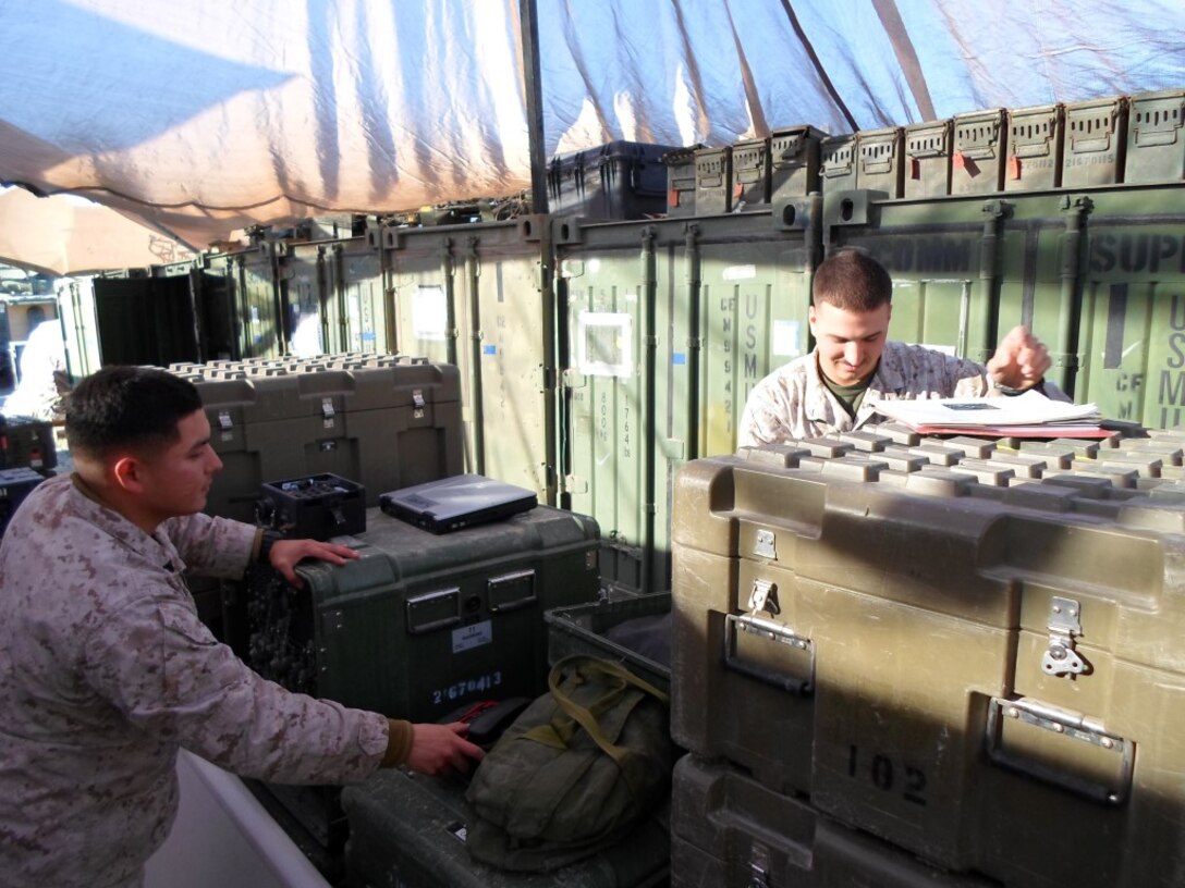 U.S. Marines Lance Cpl. Carlen Stone Gordon, right, and Cpl. Arturo Frias, both tactical switchboard operators with Special Purpose Marine Air Ground Task Force-Crisis Response-Central Command, check the programming of a Deployable End Office Suite (DEOS) switchboard prior to setting up expeditionary telephone communications for a Marine element deployed within the U.S. Central Command area of operation. Stone Gordon is from Lynchburg, Penn., and Frias is from Houston. This is the first deployment for both Marines, and they want send well wishes to their families this holiday season. (U.S. Marine Corps photo by Gunnery Sgt. Christine Polvorosa/Released)