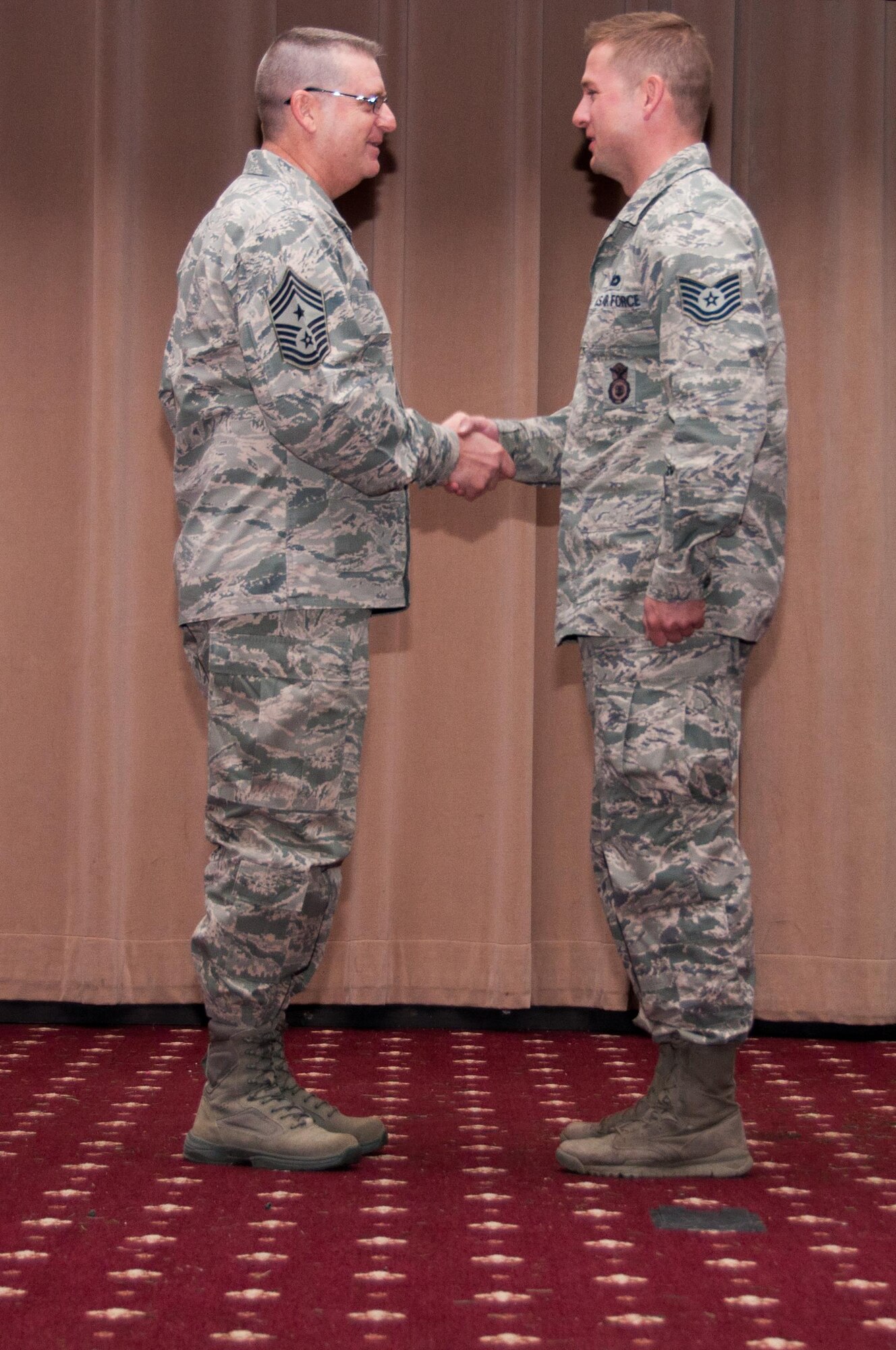 U.S. Air Force Command Chief Master Sergeant Randy Noble, of the 307th Bomb Wing, presents Tech. Sgt. Jonathan Maupin with the Command Chief Master Sergeant Award sponsored by the Chief’s Council at the 307th Bomb Wing Commander's Call on Dec. 6, 2015, Barksdale Air Force Base, La. The award was presented for embodying the Air Force Core Values. Maupin is assigned to the 307th Security Forces Squadron.  (U.S. Air Force photo by Master Sgt. Laura Siebert/Released)