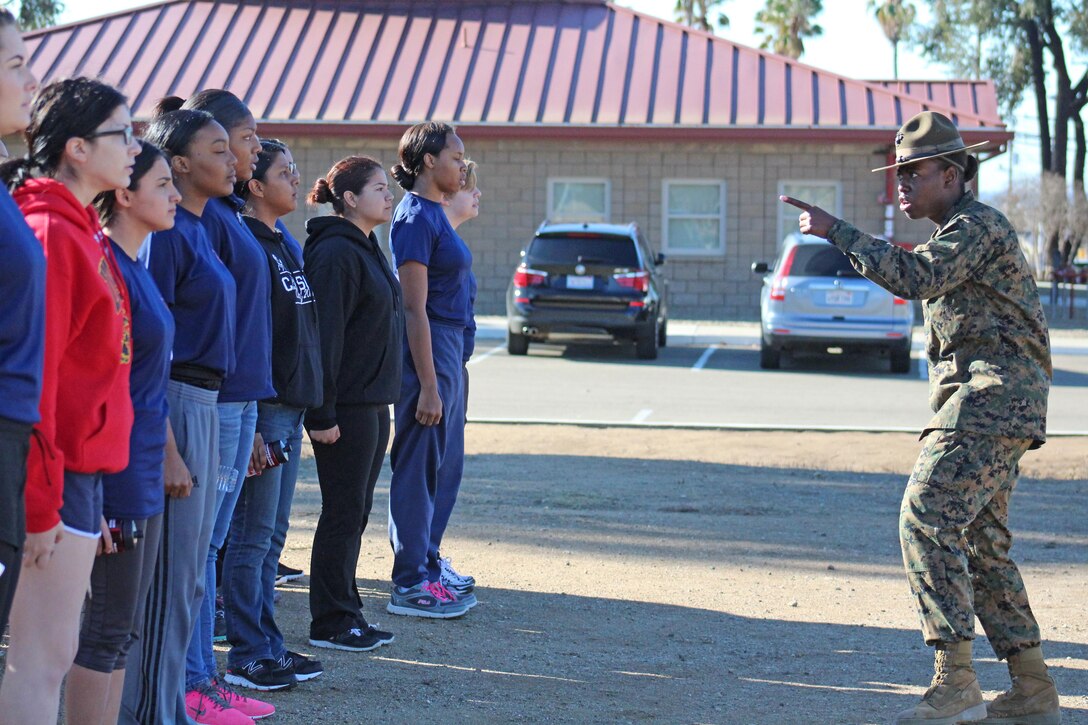 Drill Instructor Gunnery Sgt. Zhivonnie A. Edwards teaches Marine enlistees drill during a pool function at Weapons Field Training Battalion, Marine Corps Base Camp Pendleton, Calif., Dec. 12, 2015. During the event, recruiters teamed with drill instructors to mentally and physically prepare enlistees from Los Angeles, San Diego and Orange County for boot camp and taught classes about military appearance and Marine Corps history. (U.S. Marine Corps photo by Staff Sgt. Alicia R. Leaders/Released)
