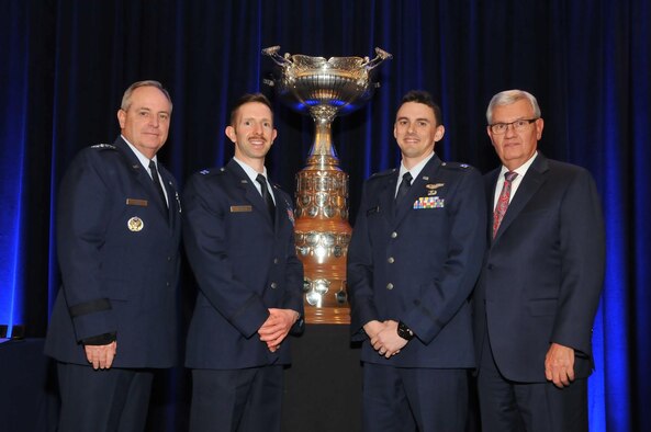 U.S. Air Force Chief of Staff Gen. Mark Welsh accompanied by a National Aeronautic Association spokesman present the Mackay Trophy to Capts. David Kroontje and Gregory Balzhiser during the NAA fall awards ceremony in Arlington, Virginia, Dec. 3, 2015. The trophy is awarded for the “most meritorious flight of the year by an Air Force person, persons, or organization.” Kroontje and Balzhiser earned the trophy as a result of their heroic efforts during an air strike that helped Peshmerga forces the next day set up a safe corridor from Mount Sinjar, Iraq, saving the lives of 40,000 stranded civilians including women, children, elderly, and the infirm. Kroontje has since transferred to the 560th Flying Training Squadron at Randolph Air Force Base, Texas, and Balzhiser is now a member of the 31st Operations Support Squadron at Aviano Air Base, Italy. (Courtesy photo)