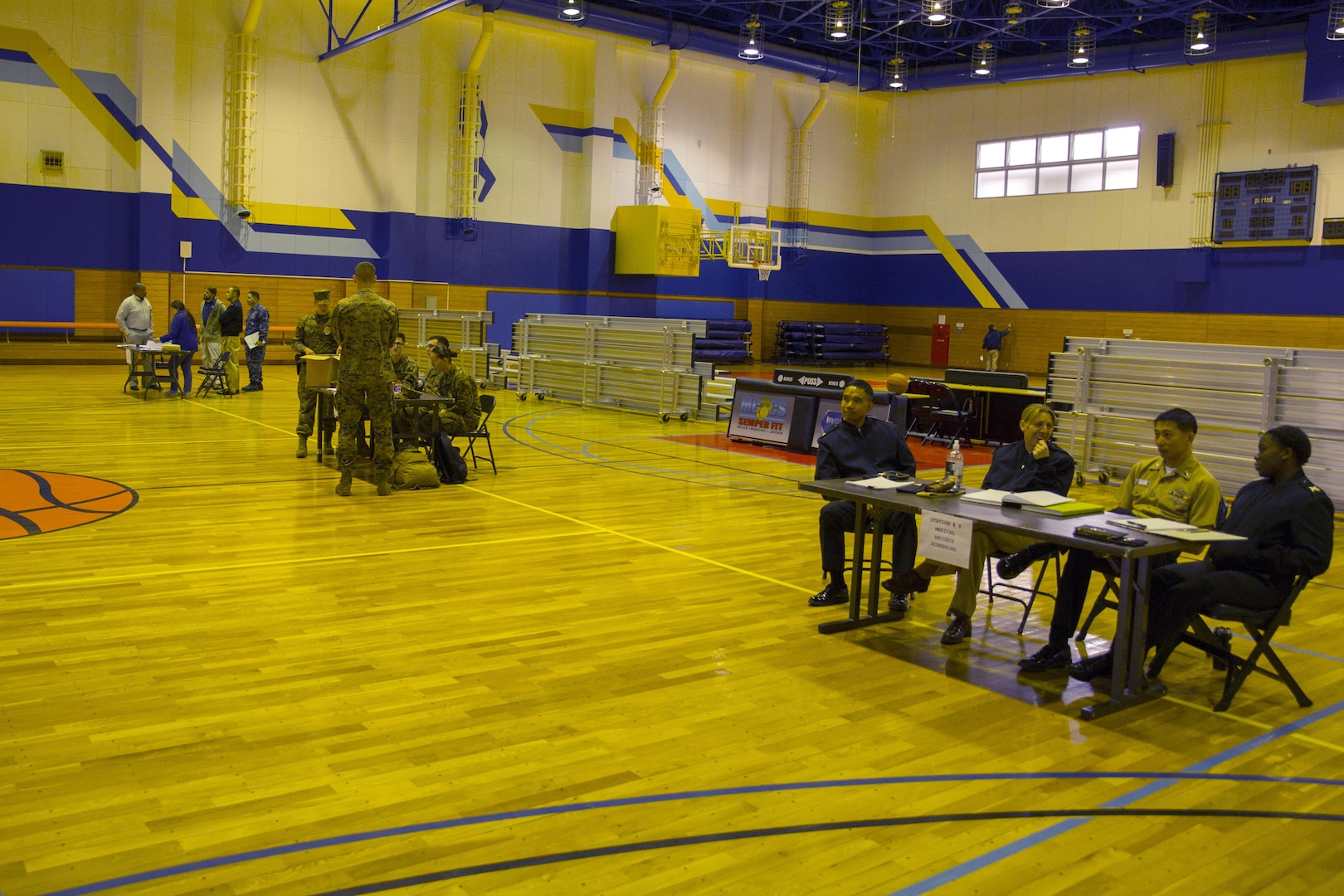Station residents provide required information to the Navy and Marine Corps Relief Society, and American Red Cross during a noncombatant evacuation processing center exercise in the IronWorks Gym at Marine Corps Air Station Iwakuni, Japan, Dec. 11, 2015. This exercise practices evacuating endangered personnel in a host foreign nation to a safe location. An evacuation can take place for a variety of reasons such as natural disasters, industrial accidents and military threats.