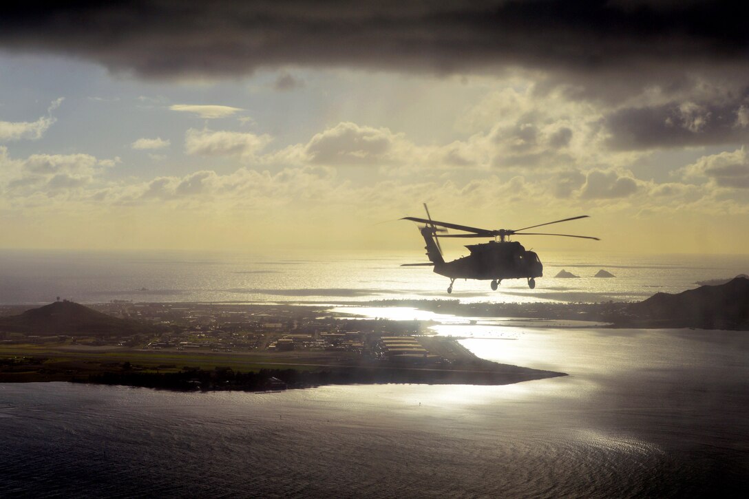 A UH-60 Black Hawk helicopter transports soldiers in the early morning near Marine Corps Air Station Kaneohe Bay, Hawaii, Dec. 2, 2015. U.S. Army photo by Staff Sgt. Armando Limon