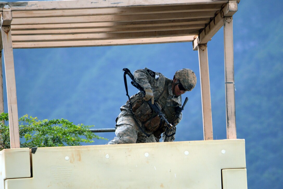 A soldier climbs into a guard shack on Marine Corps Training Area Bellows, Hawaii, Dec. 2, 2015. U.S. Army photo by Staff Sgt. Armando Limon