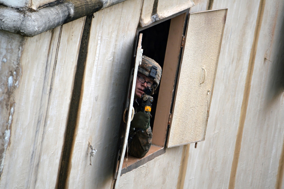 A soldier looks out a window during a training exercise on Marine Corps Training Area Bellows, Hawaii, Dec. 2, 2015. U.S. Army photo by Staff Sgt. Armando Limon
