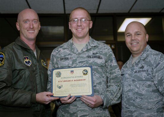 Airman 1st Class Brian Boarman is flanked by Lt. Col. Michael Drost (left) and Chief Master Sgt. Kraig Chapman at the Vance weather center, Dec. 8. The 71st Operations Support Squadron commander and superintendent respectively informed Boarman that he is one of Team Vance's two recent Below-the-Zone promotion recipients. BTZ allows commanders to promote a select number of outstanding airmen 1st class to senior airmen six months early. The weather forecaster will put on senior airman just after the new year. (U.S. Air Force photo / David Poe)