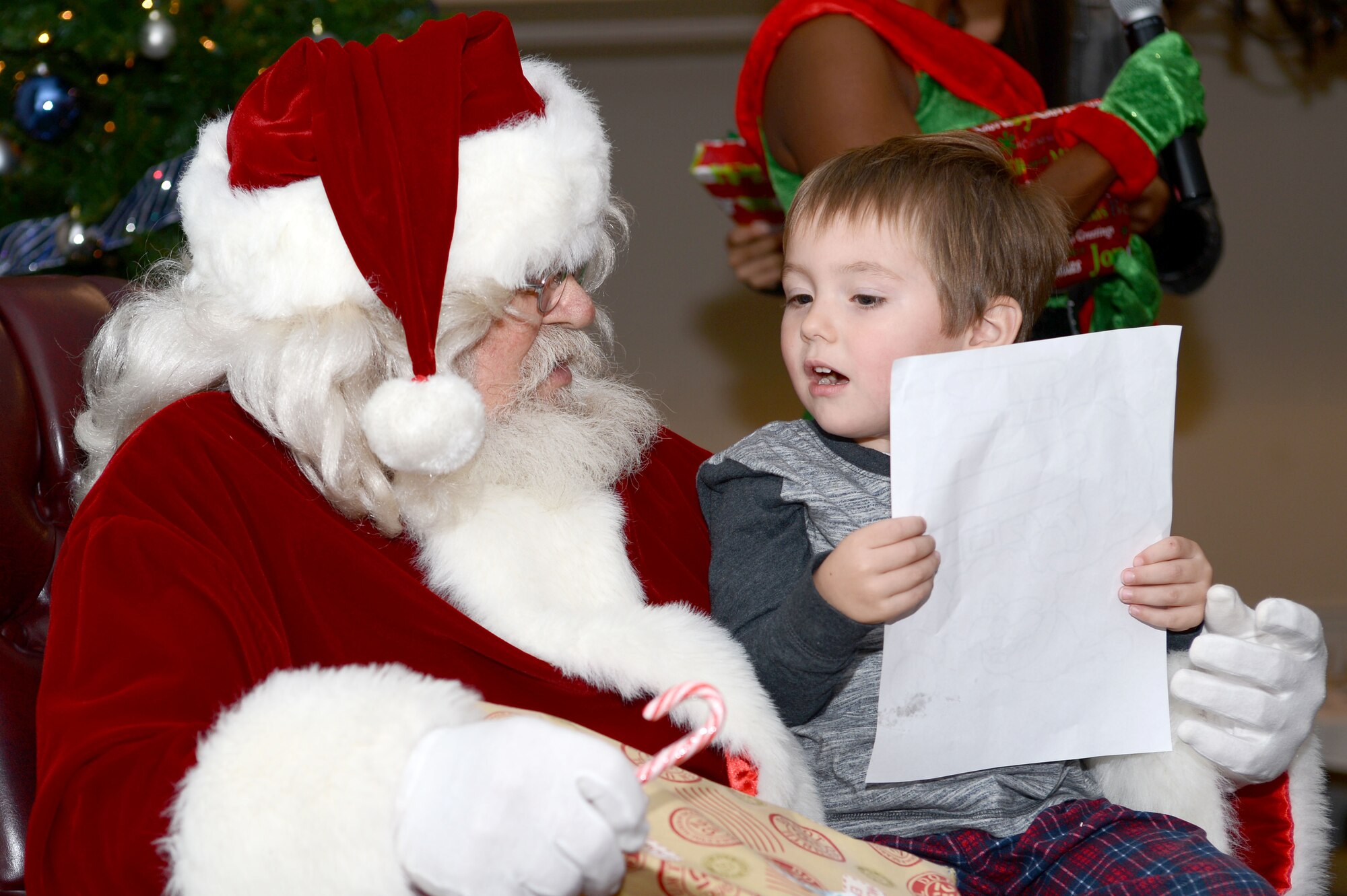 Ryder Martin, child of U.S. Air Force Special Agent Josh Martin, Office of Special Investigations Detachment 212 special agent, explains a picture he colored for Santa Claus before receiving a gift at the Carolina Skies Club and Conference Center at Shaw Air Force Base, S.C., Dec. 12, 2015. Santa visited with Team Shaw children as part of the 20th Force Support Squadron’s “Breakfast with Santa in your Pajamas” event, for which children and their families were invited to Carolina Skies to eat breakfast and watch holiday movies in their pajamas before meeting Santa Claus. (U.S. Air Force photo by Senior Airman Zade Vadnais)
