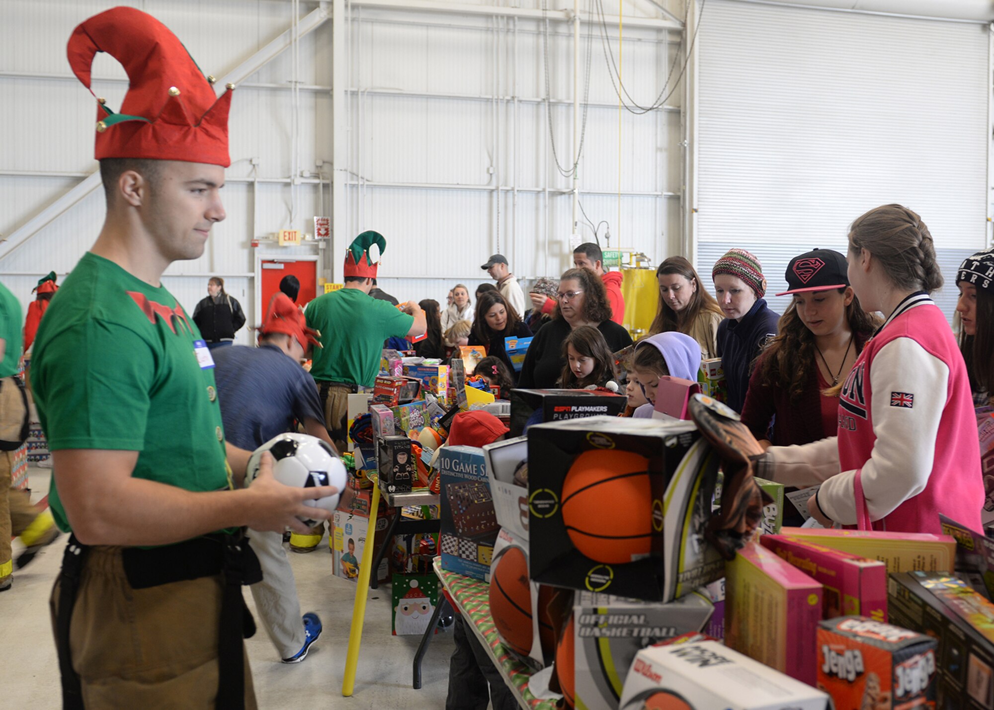 Members of Team Beale receive gifts during the annual Children's Holiday Party Dec. 12, 2015, at Beale Air Force Base, California. Thousands of presents were donated by multiple suppliers and were handed out to the children of Team Beale. In addition, the event included photos with Santa Clause and his elves, a raffle and various holiday activities. (U.S. Air Force photo by Airman 1st Class Ramon A. Adelan)