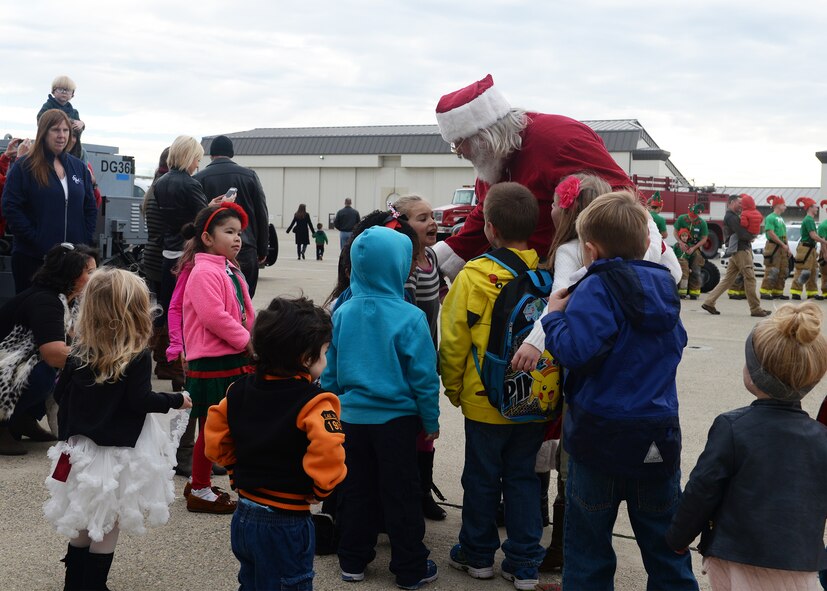 Children of Team Beale surround Santa Clause during the annual Children's Holiday Party Dec. 12, 2015, at Beale Air Force Base, California. Thousands of presents were donated by multiple suppliers and were handed out to the children of Team Beale. In addition, the event included photos with Santa Clause and his elves, a raffle and various holiday activities. (U.S. Air Force photo by Airman 1st Class Ramon A. Adelan)