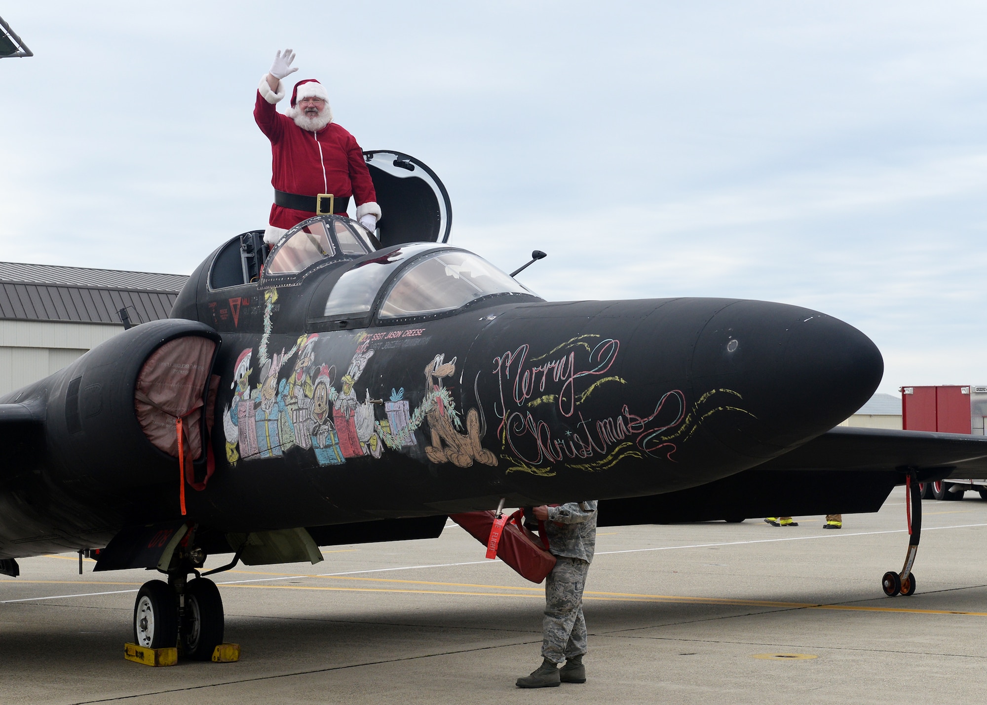 Santa Clause emerges from a U-2 Dragon Lady during the annual Children's Holiday Party Dec. 12, 2015, at Beale Air Force Base, California. Thousands of presents were donated by multiple suppliers and were handed out to the children of Team Beale. In addition, the event included photos with Santa Clause and his elves, a raffle and various holiday activities. (U.S. Air Force photo by Airman 1st Class Ramon A. Adelan)