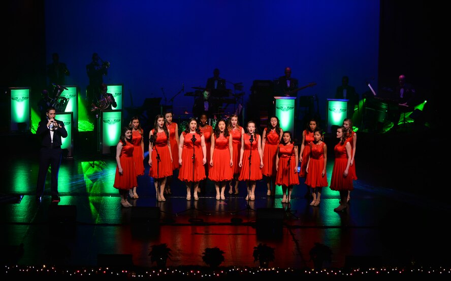 The Bellevue East High School’s Take II show choir takes center stage during a performance by the United States Air Force Heartland of America Band at the Bellevue East High School on Dec. 12 in Bellevue, Neb. The performance was part of the band’s annual “Sounds of the Season” holiday concert series. The band will perform at three area high schools as part of the series. (U.S. Air Force photo by Josh Plueger)