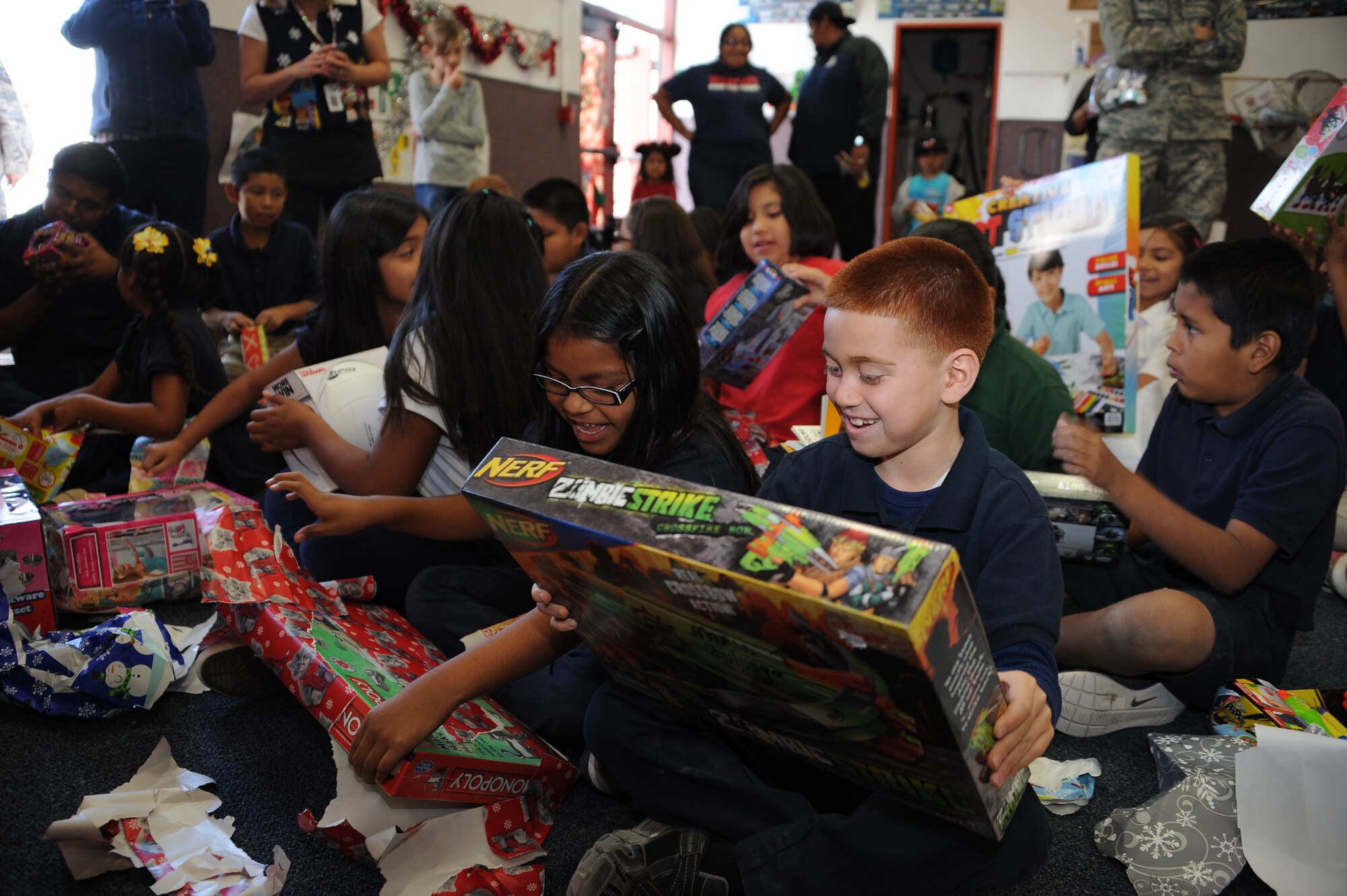 San Xavier Mission School students open gifts during Davis-Monthan Air Force Base’s 50th Anniversary Santas in Blue event in Tucson, Ariz., Dec. 10, 2015. More than 100 students received gifts that were collected and distributed by D-M AFB volunteers. (U.S. Air Force photo by Airman 1st Class Ashley N. Steffen/Released)
  
