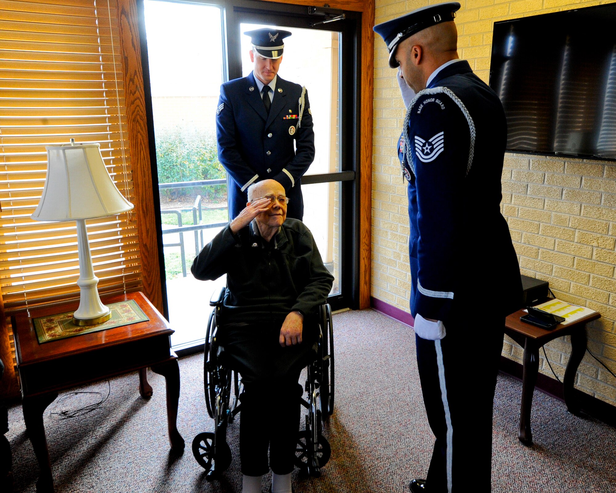 Roy Mullinax, a former Airman, returns a salute to Tech. Sgt. Terrance Williams, 22nd Air Refueling Wing Honor Guard NCO in charge, after being presented with a veteran’s pin during a recognition ceremony, Dec. 8, 2015, in Newton, Kan. Members of the 22nd ARW Honor Guard recognized Mullinax for his years of service during a special ceremony at the request of his family. (U.S. Air Force photo/Senior Airman Victor J. Caputo)