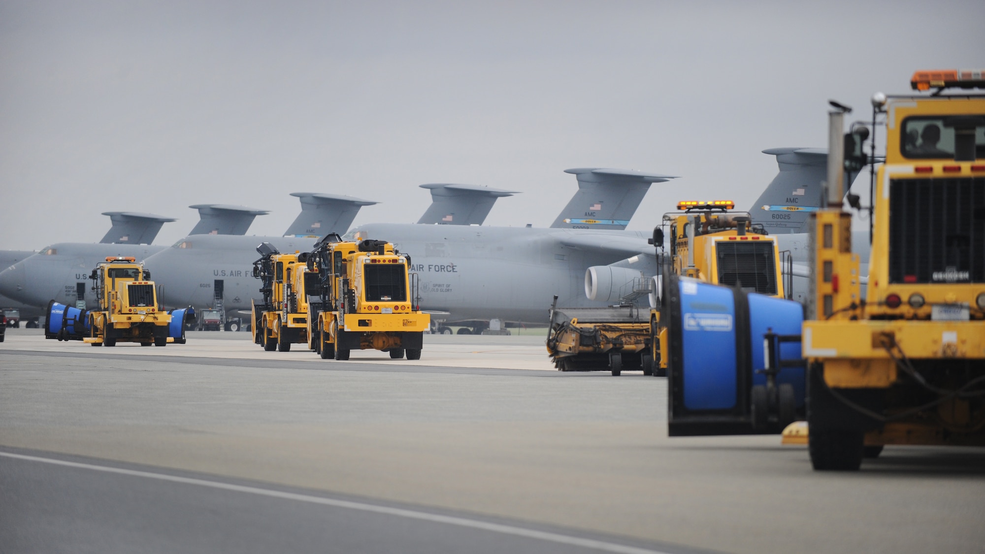 Snow removal vehicles from the 436th Civil Engineer Squadron drive down the flight line during the annual snow parade Nov. 6, 2015, at Dover Air Force Base, Del.  Many members of Team Dover leadership were given the opportunity to ride or drive in the vehicles. (U.S. Air Force photo/Tech. Sgt. Elizabeth Morris)