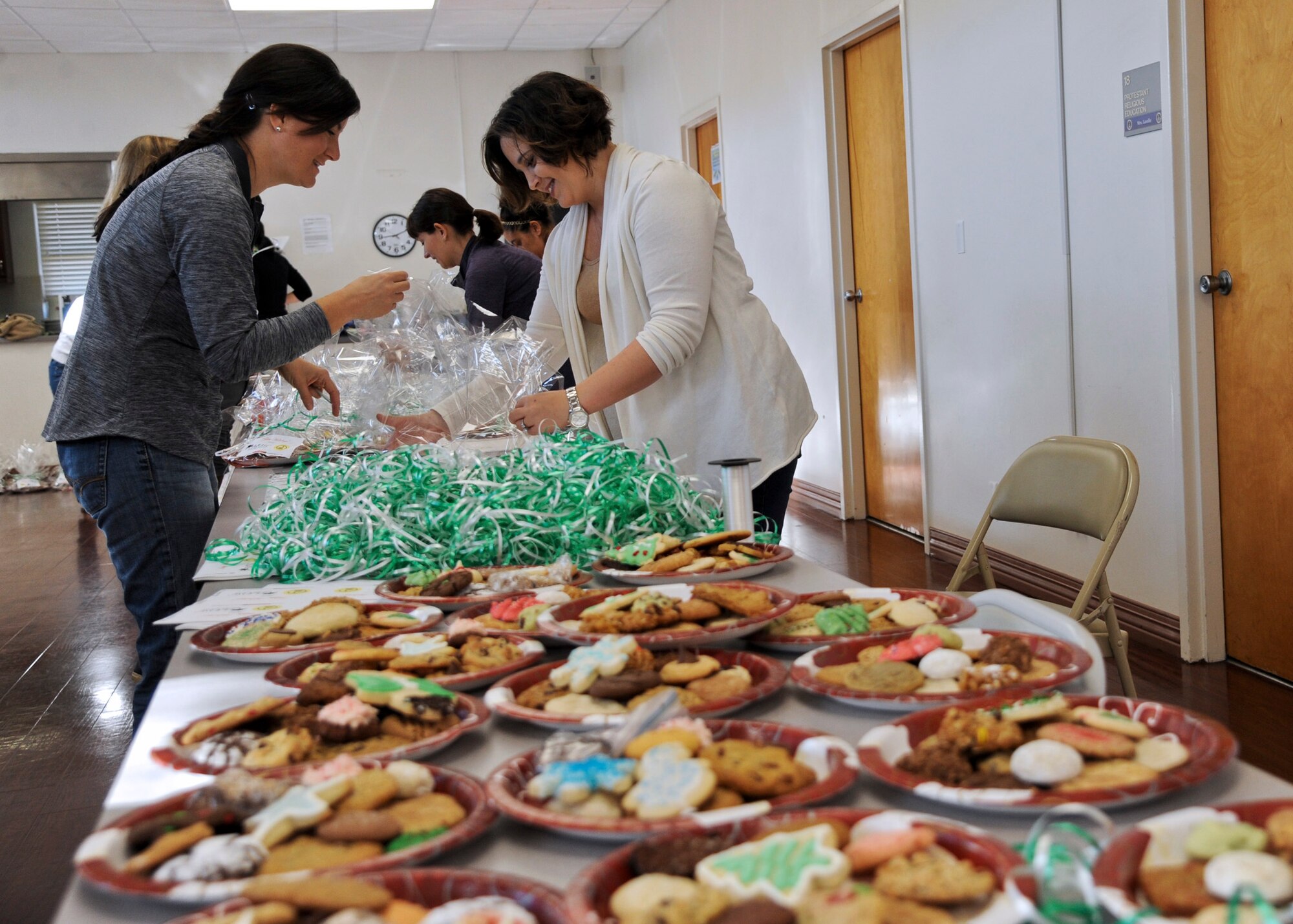 MacDill Officers’ Spouses’ Club members Roberta Schalles, left, and Leslie Kanak, right, wrap a plate of homemade cookies for a dorm resident during Operation Cookie Drop 2015 at MacDill Air Force Base, Fla., Dec. 8, 2015. Each dorm resident was given an assortment of 12 homemade cookies. (U.S. Air Force photo by Senior Airman Danielle Quilla)