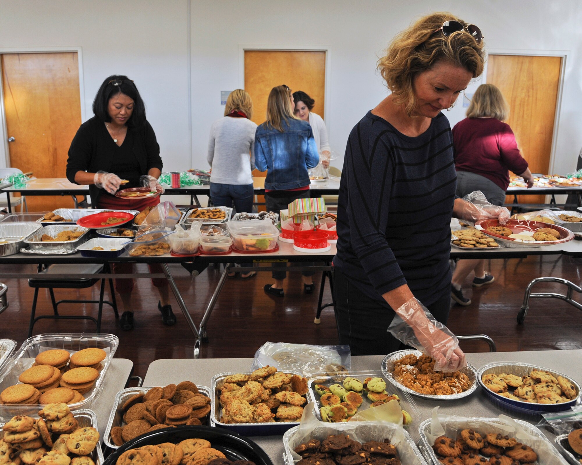Members of the officers’ and the enlisted spouses’ clubs at MacDill Air Force Base, Fla., assemble plates of homemade cookies in the base chapel annex during the Operation Cookie Drop 2015 Dec. 8, 2015. The event was a way to bring a little taste of home to dorm residents during the holiday season. (U.S. Air Force photo by Senior Airman Danielle Quilla)