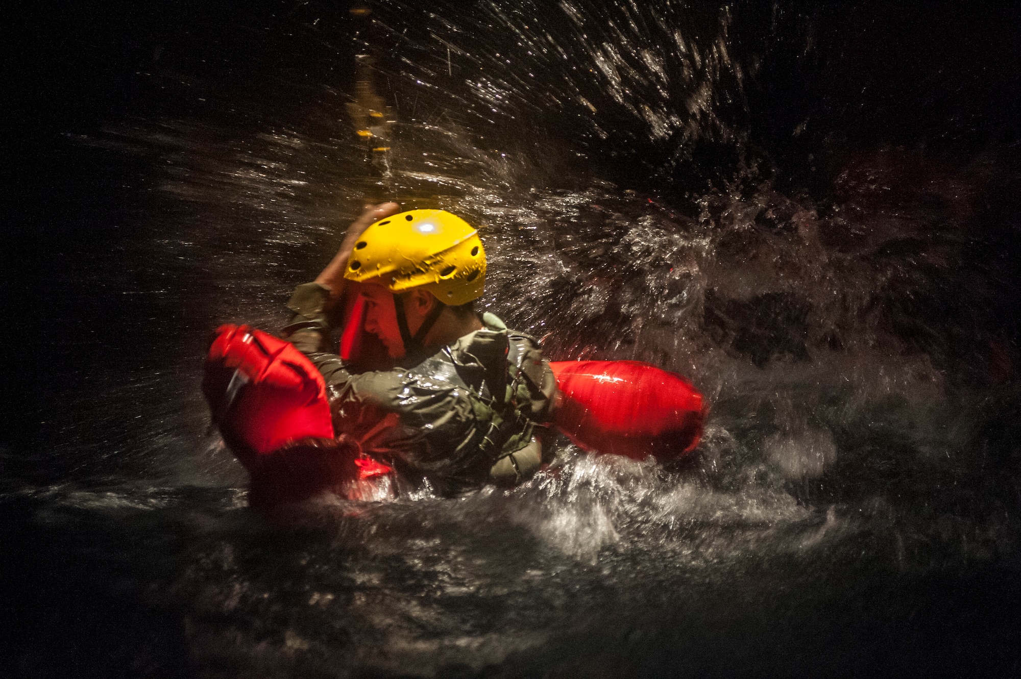 A Water Survival student braves the turbulent waters before getting hoisted into the fuselage during a training scenario Dec. 8, 2015, at Fairchild Air Force Base, Wash. The survival gear available to Airmen depends on what aircraft they are flying in and under what command the aircraft is flying. Different commands pack different items, but as a standard, aircraft have a raft, raft canopy, canopy poles, rations, medical supplies, radio, signaling devices and a form of water or a way of procuring fresh water. (U.S. Air Force photo/Airman 1st Class Sean Campbell)