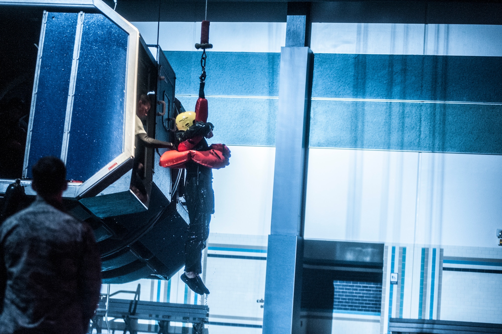 A Water Survival student gets hoisted back into a training fuselage by a Survival, Evasion, Resistance and Escape instructor during a training scenario Dec. 8, 2015, at Fairchild Air Force Base, Wash. Course capacity is capped at 34 students and is primarily made up of flight crew members and battlefield Airmen, but can also include members from other career fields and each branch of service. (U.S. Air Force photo/Airman 1st Class Sean Campbell)