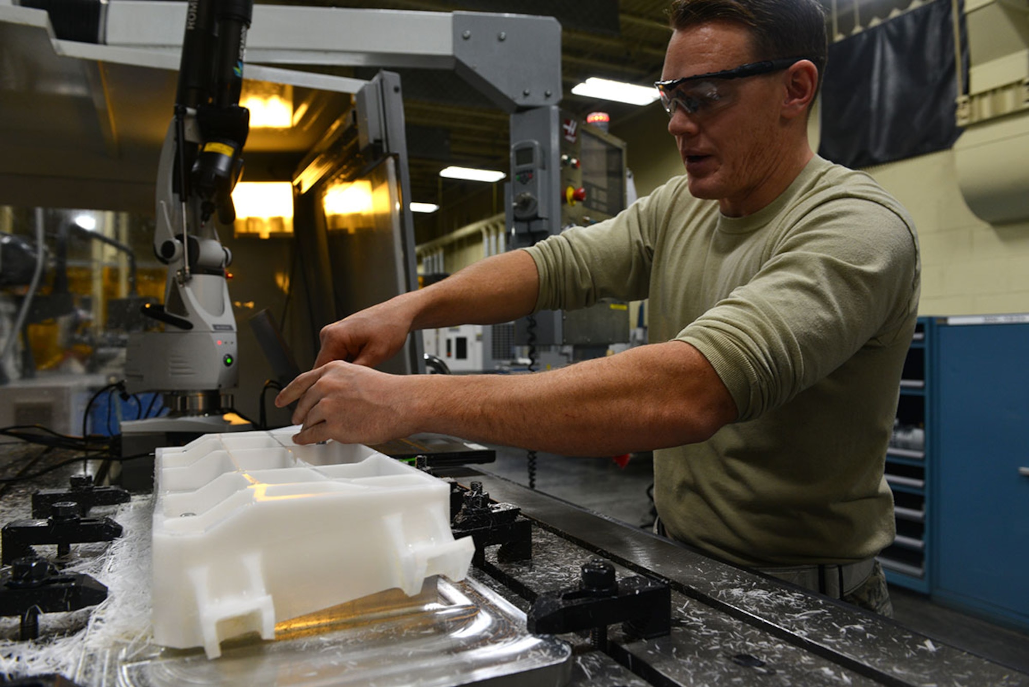 Air Force Staff Sgt. Jeremy Hamblin, 3rd Maintenance Squadron, Aircraft Metals Technology Flight craftsman, measures inconsistencies on a plastic mold in the Aircraft Metals Technology building November 24. After measuring the discrepancies, Hamblin can plug the data into the system to ensure they are not replicated on the aluminum billet. (U.S. Air Force photo by Airman 1st Class Kyle Johnson)