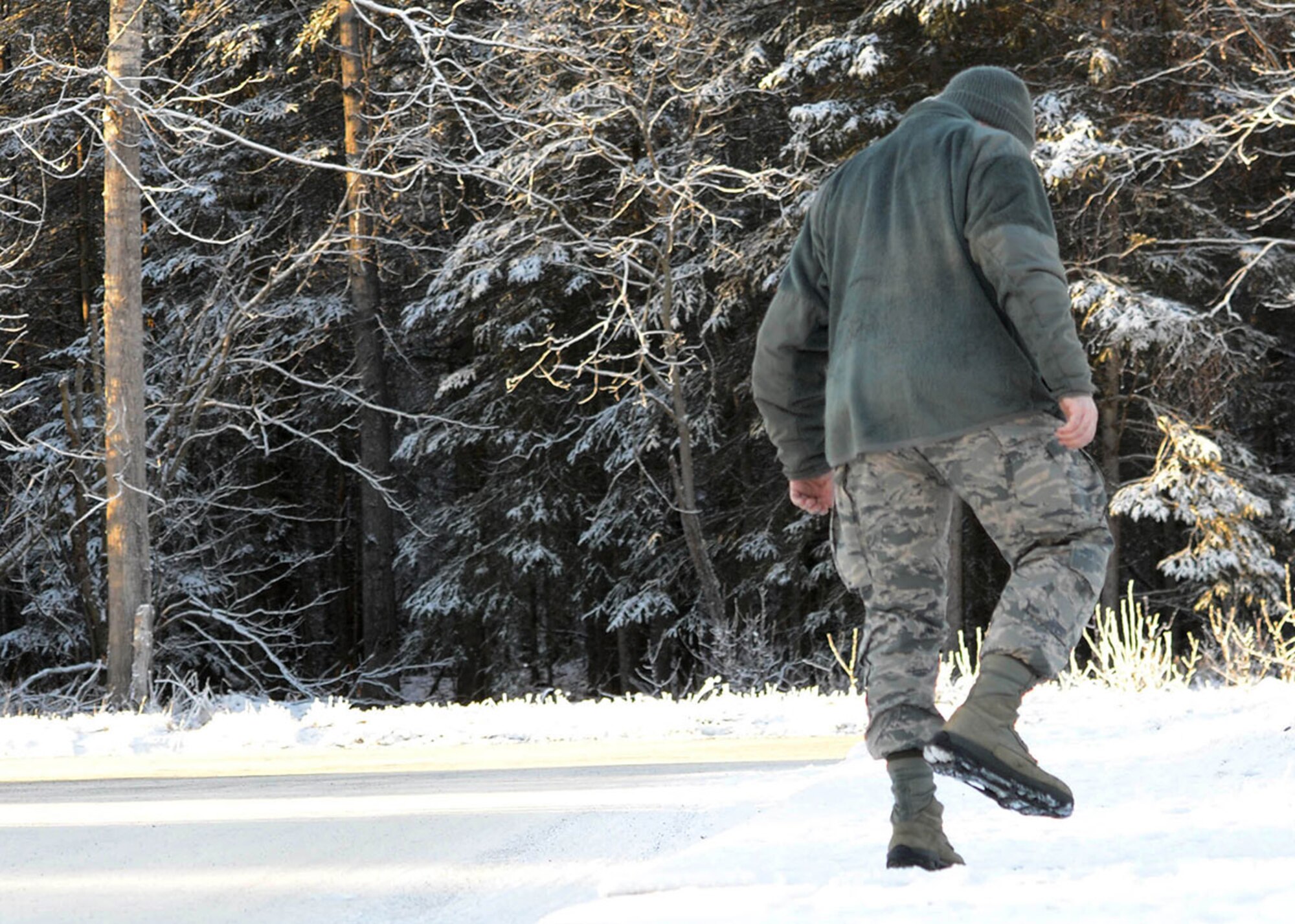 Airman 1st Class Christopher R. Morales, 673d Air Base Wing Public Affairs photojournalist at Joint Base Elmendorf-Richardson, Alaska, walks along an icy trail, Dec. 10, 2015. Military members are encouraged to wear ice cleats when traversing through icy and snow covered pathways. (U.S. Air Force photo by Airman 1st Class Javier Alvarez)