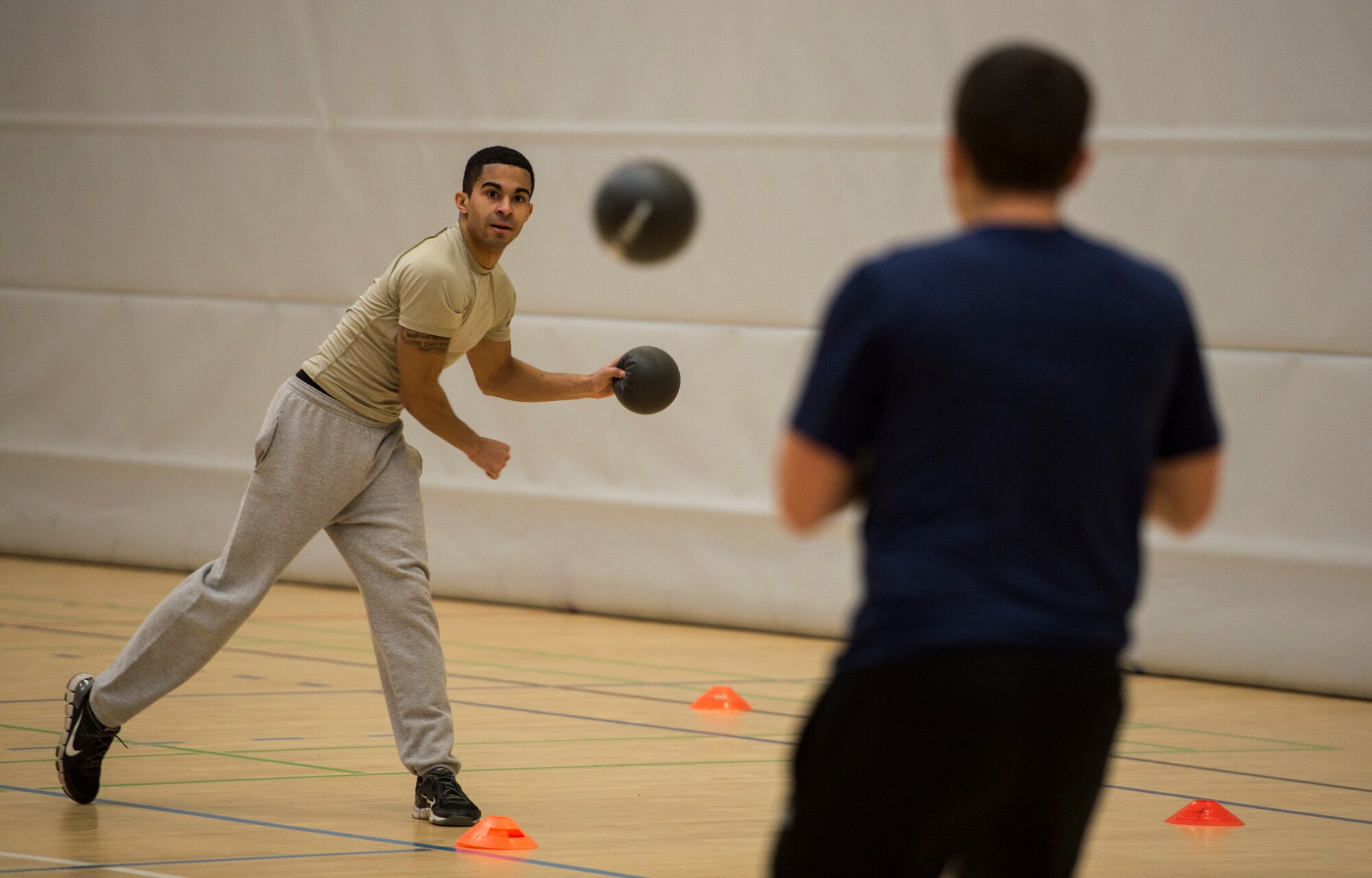 U.S. Air Force Senior Airman Sean Walker, American Forces Network Spangdahlem broadcast journalist, hurls a dodgeball at an opposing player during the RUFit Dodgeball Tournament in the fitness center Dec. 11, 2015, at Spangdahlem Air Base, Germany. Information booths from the four pillars of RUFit, social, mental, spiritual and physical, were set up to provide information to the players during the games. (U.S. Air Force photo by Staff Sgt. Christopher Ruano/Released)