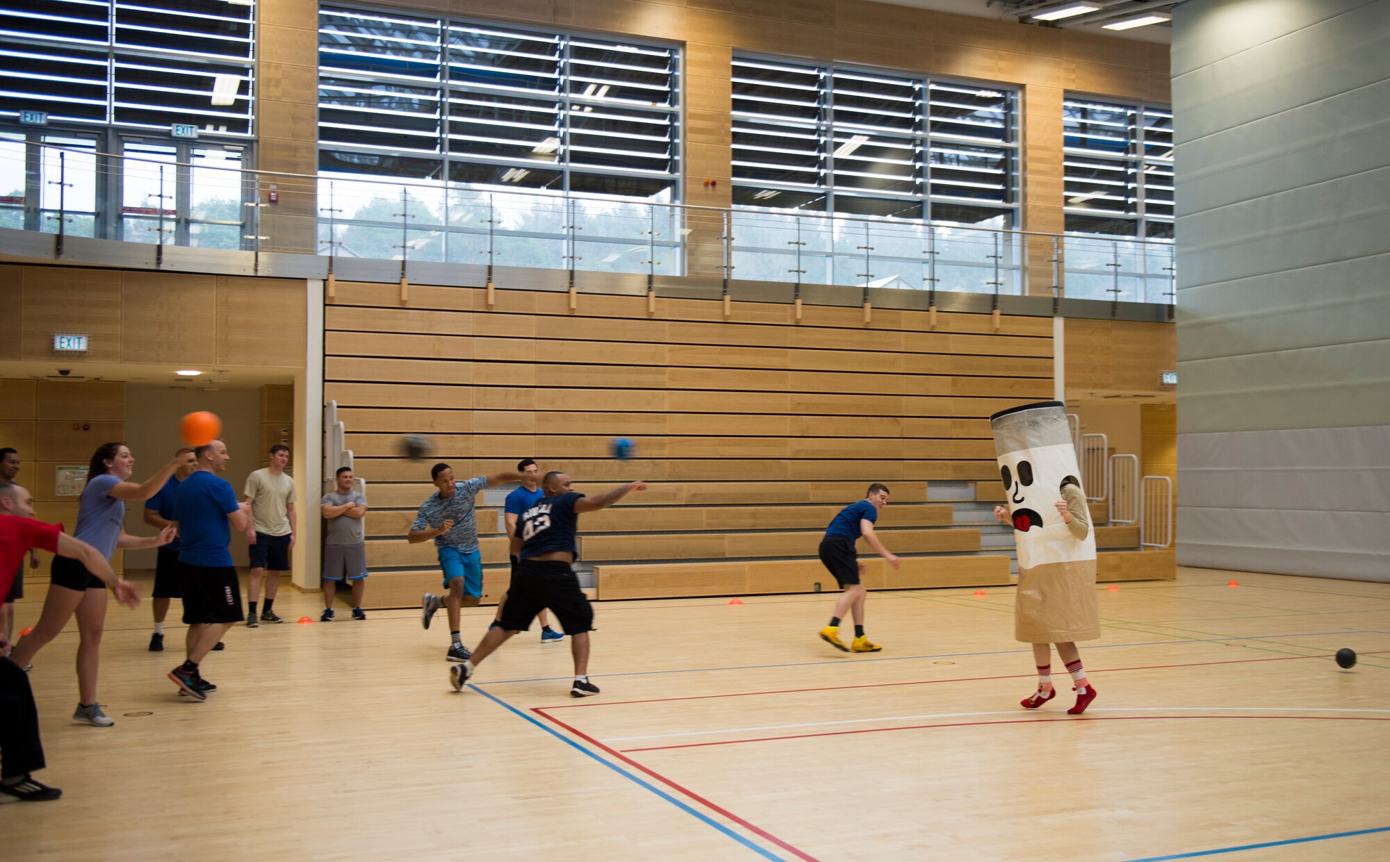 Airmen pummel a cigarette mascot with dodgeballs to warm up for the RUFit Dodgeball Tournament in the fitness center Dec. 11, 2015, at Spangdahlem Air Base, Germany. Information booths from the four pillars of RUFit, social, mental, spiritual and physical, were set up to provide information to the players during the games. (U.S. Air Force photo by Staff Sgt. Christopher Ruano/Released)