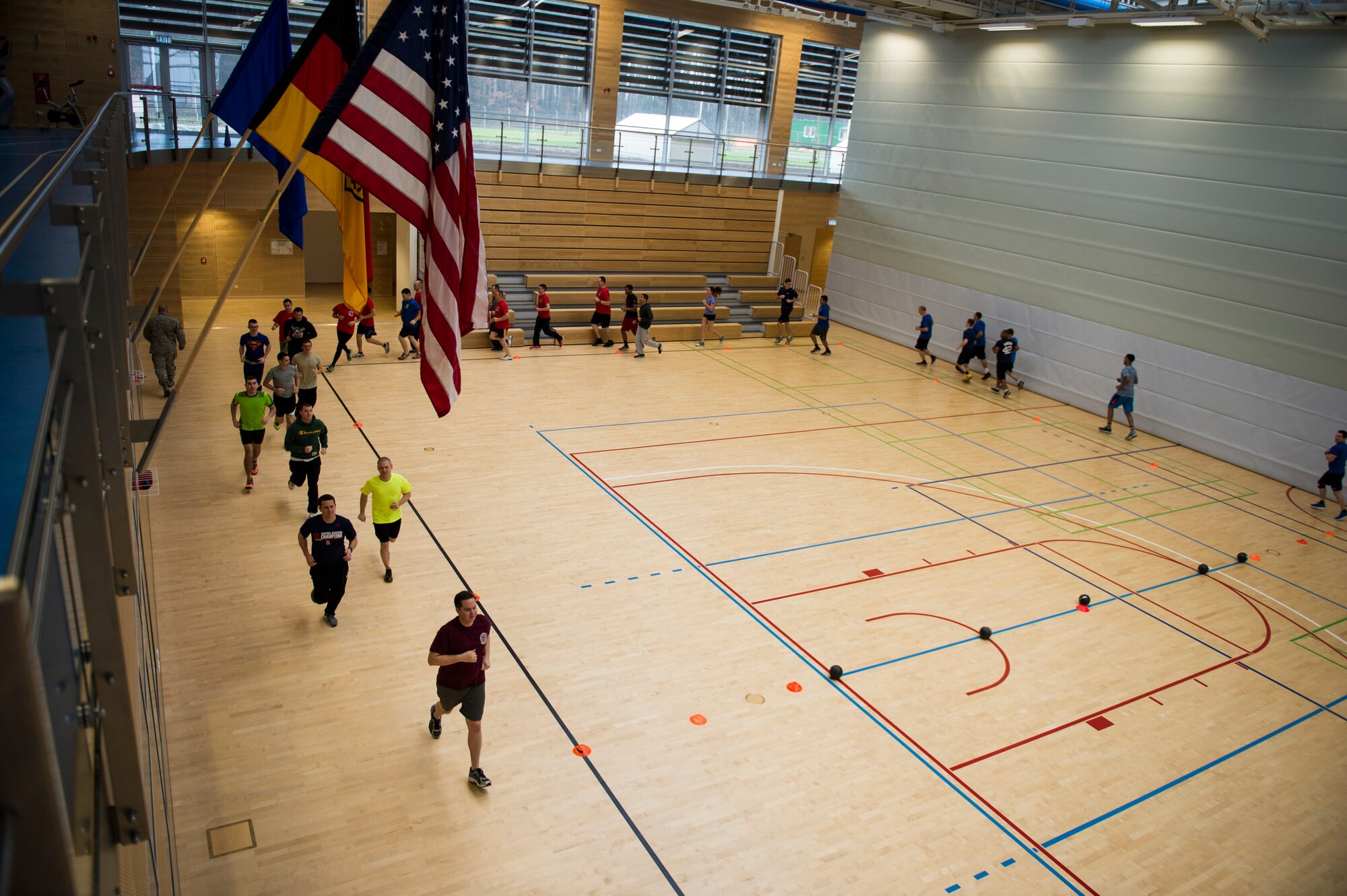 Airmen run around the court to warm up for the RUFit Dodgeball Tournament in the fitness center Dec. 11, 2015, at Spangdahlem Air Base, Germany. Warm-ups consisted of multiple cardio routines followed by arm and leg stretches before the game began. (U.S. Air Force photo by Staff Sgt. Christopher Ruano/Released)