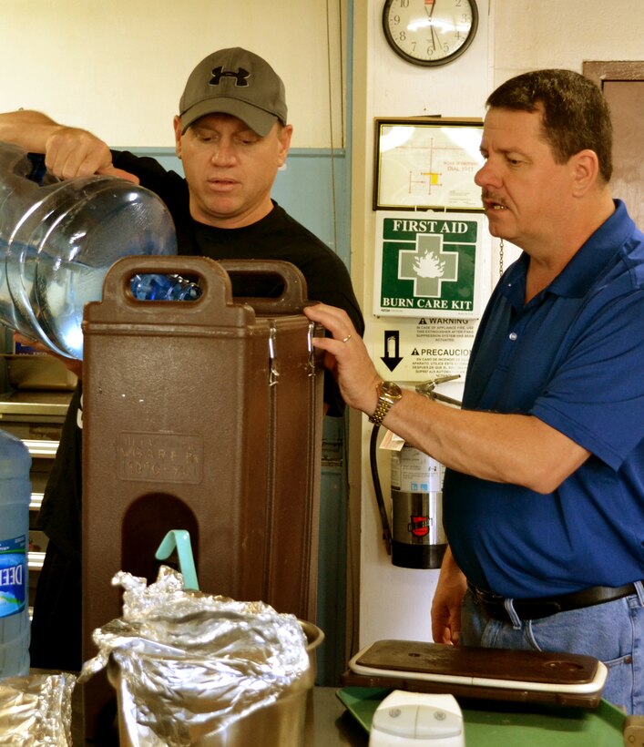 Capt. Daniel Taylor, left, a logistics readiness officer with the 111th Attack Wing, and Chief Master Sgt. James Finn, the superintendent of the 111th Security Forces Squadron, make iced tea for a holiday party held for severely-disabled adults in the dining facility at Horsham Air Guard Station, Pennsylvania, Dec. 13, 2015. The guests were presented with food, music, gifts and a visit by Santa Claus during the annual event.  (U.S. Air National Guard photo by Tech. Sgt. Andria Allmond/Released)