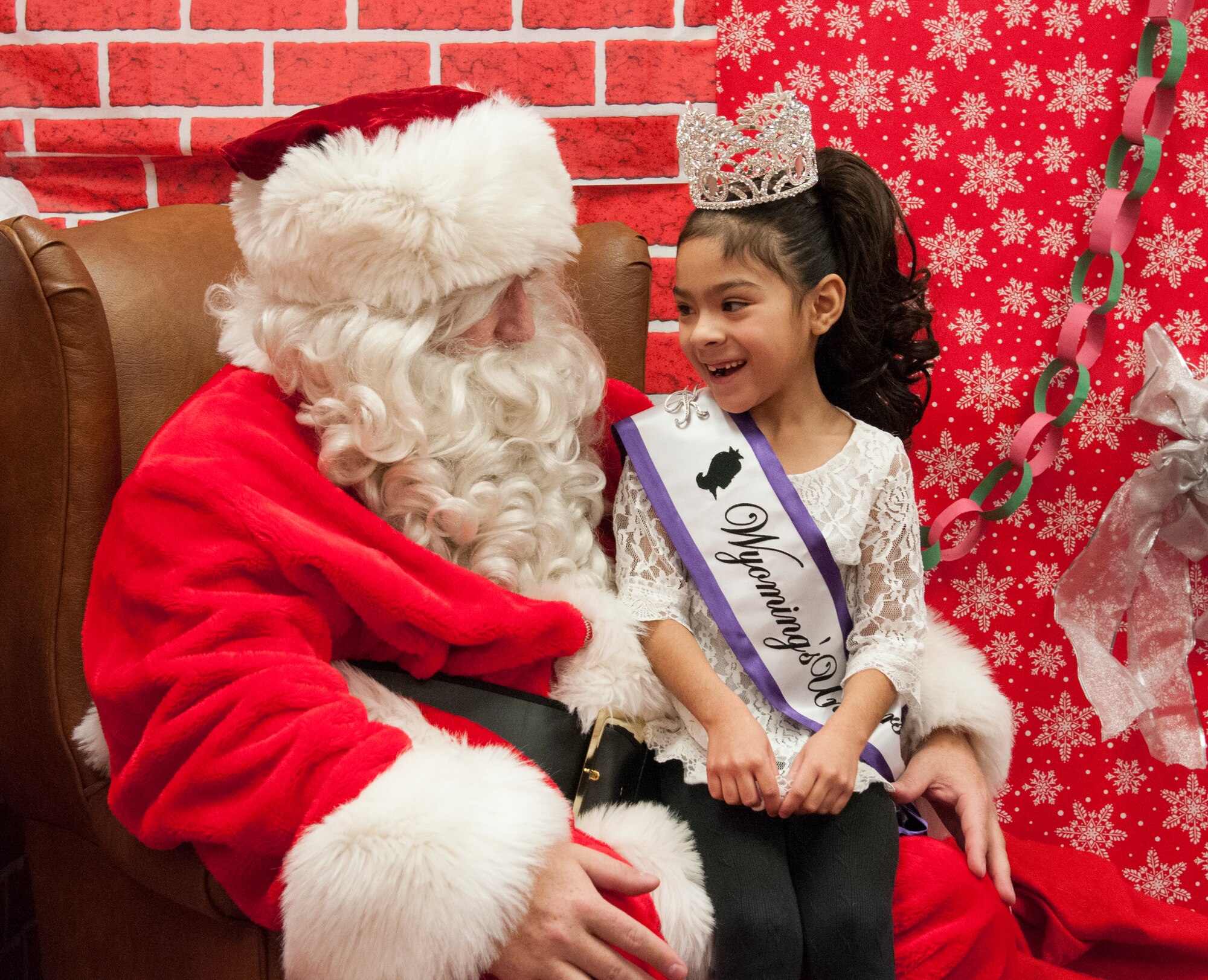 Santa Claus talks with Kasey Valerio, 6, daughter of Staff Sgt. Mario Valerio, 153rd Command and Control Squadron, during the 2015 Operation Provide Joy event  Dec. 12 in the Fall Hall Community Center on F.E. Warren Air Force Base, Wyo. Santa and his elves visited to bring holiday cheer to the children visiting the base from the local community. (U.S. Air Force photo by Senior Airman Jason Wiese)