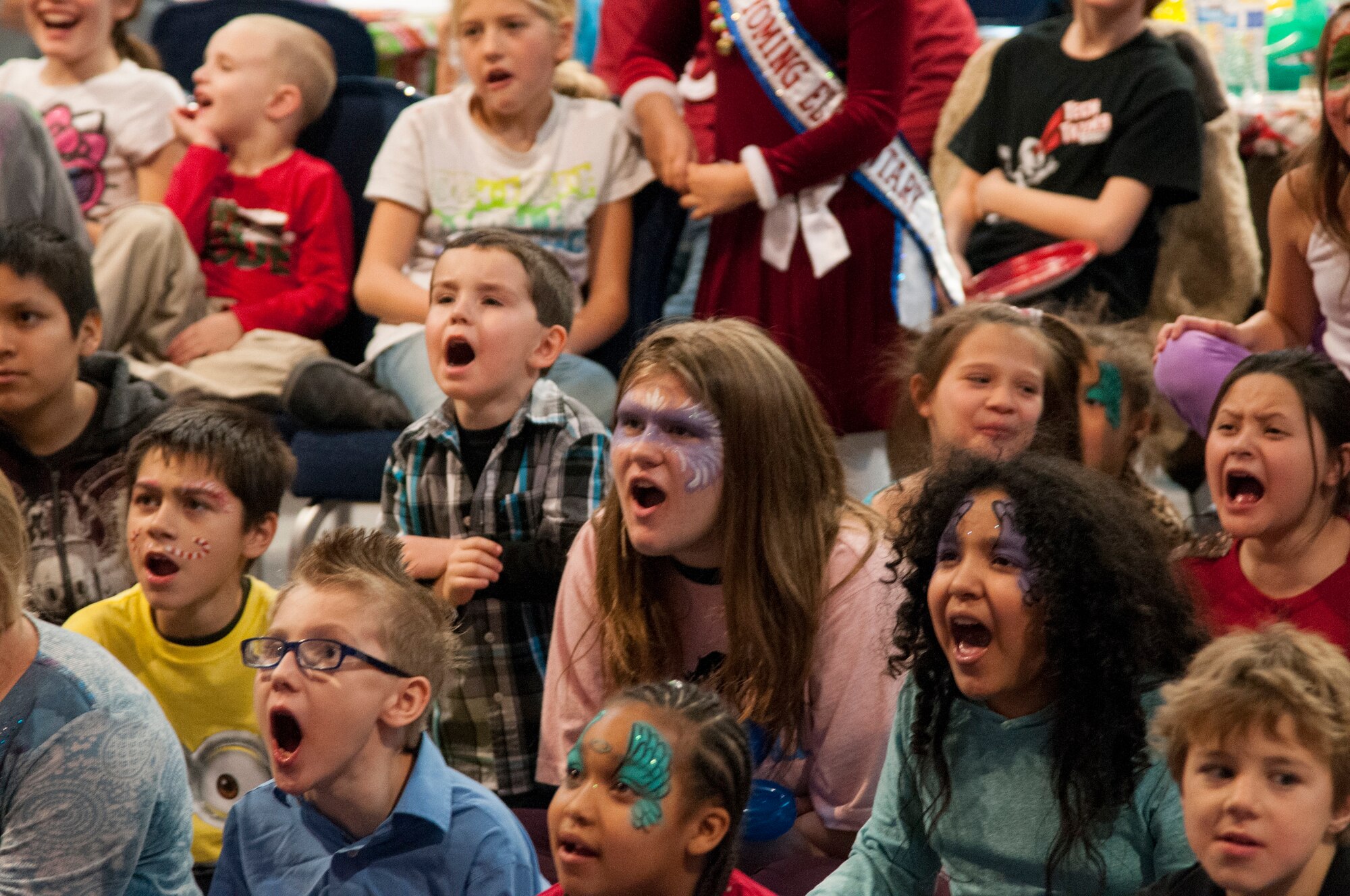 Children shout encouragement to a magician during his show in the Fall Hall Community Center on F.E. Warren Air Force Base, Wyo., Dec 12 during the 2015 Operation Provide Joy event. Each year, about 100 children visit the base during the holiday season to play games, make crafts, meet Santa Claus and more. (U.S. Air Force photo by Senior Airman Jason Wiese)