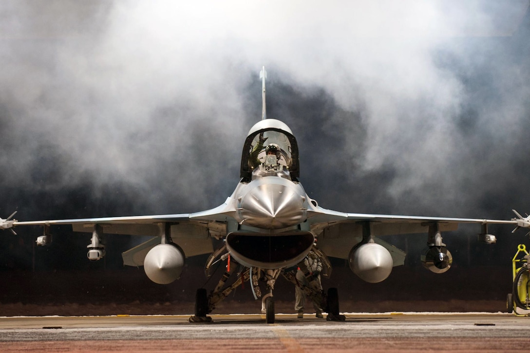 Air Force Lt. Col. Mark Sletten lowers the canopy on an F-16 Fighting Falcon before taxiing to take off at Eielson Air Force Base, Alaska, Dec. 7, 2015. Sletten is an F-35 Lightning II program integration officer. U.S. Air Force photo by Master Sgt. Joseph Swafford