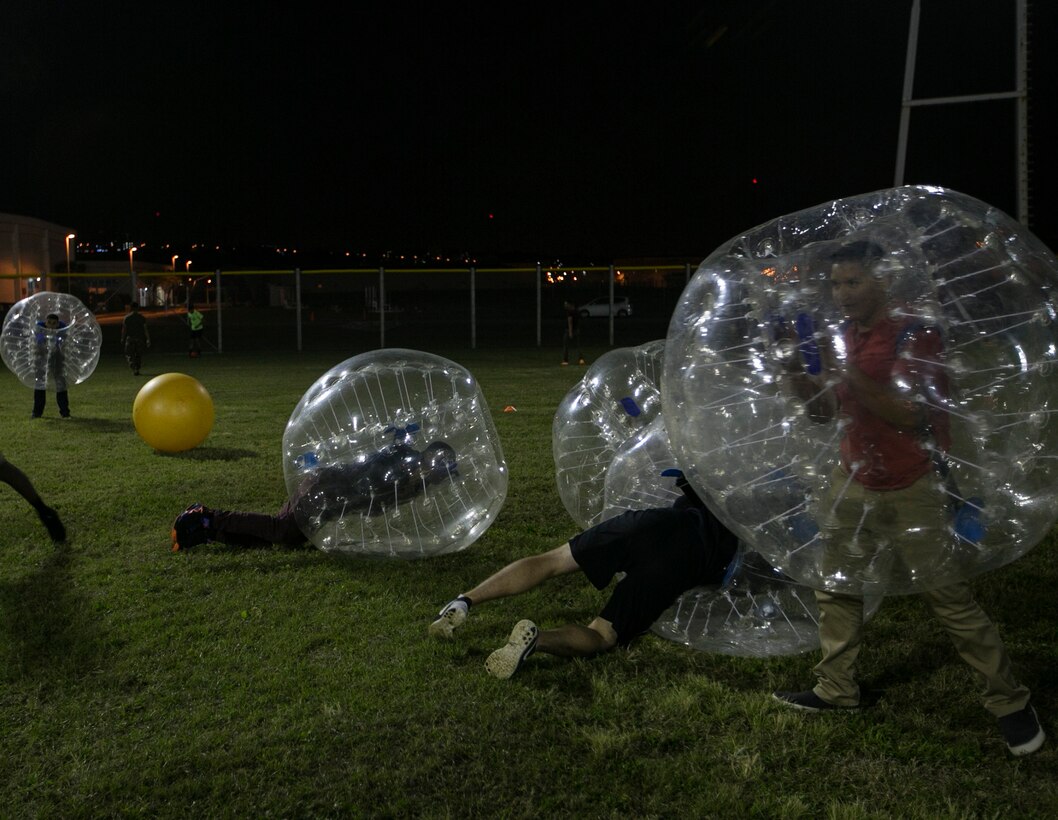 Marines and sailors participate in Elevate's main event, bubble soccer, on Camp Foster, Okinawa, Japan, Dec. 11. Elevate is a program created for service members to come together and enjoy an alcohol-free night, as well as to promote healthy behavioral choices. The coordinator of the program, U.S. Navy Lt. Todd A. Trumble, put together bubble soccer so that service members can actively end their night. Trumble, from Lynchburg, Virginia, is a chaplin with Marine Wing Support Squadron 172, 1st Marine Aircraft Wing, III Marine Expeditionary Force.  (U.S. Marine Corps photo by Lance Cpl. Jessica N. Etheridge/Released)